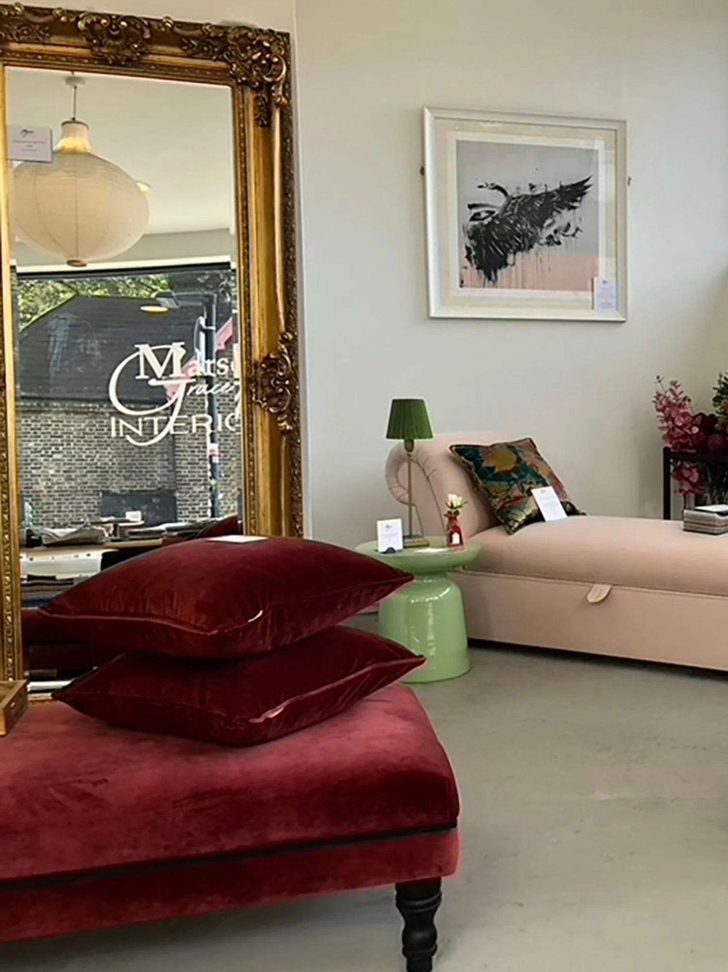 Antique gold mirror reflecting lounge with velvet cushions chaise longue and wall art