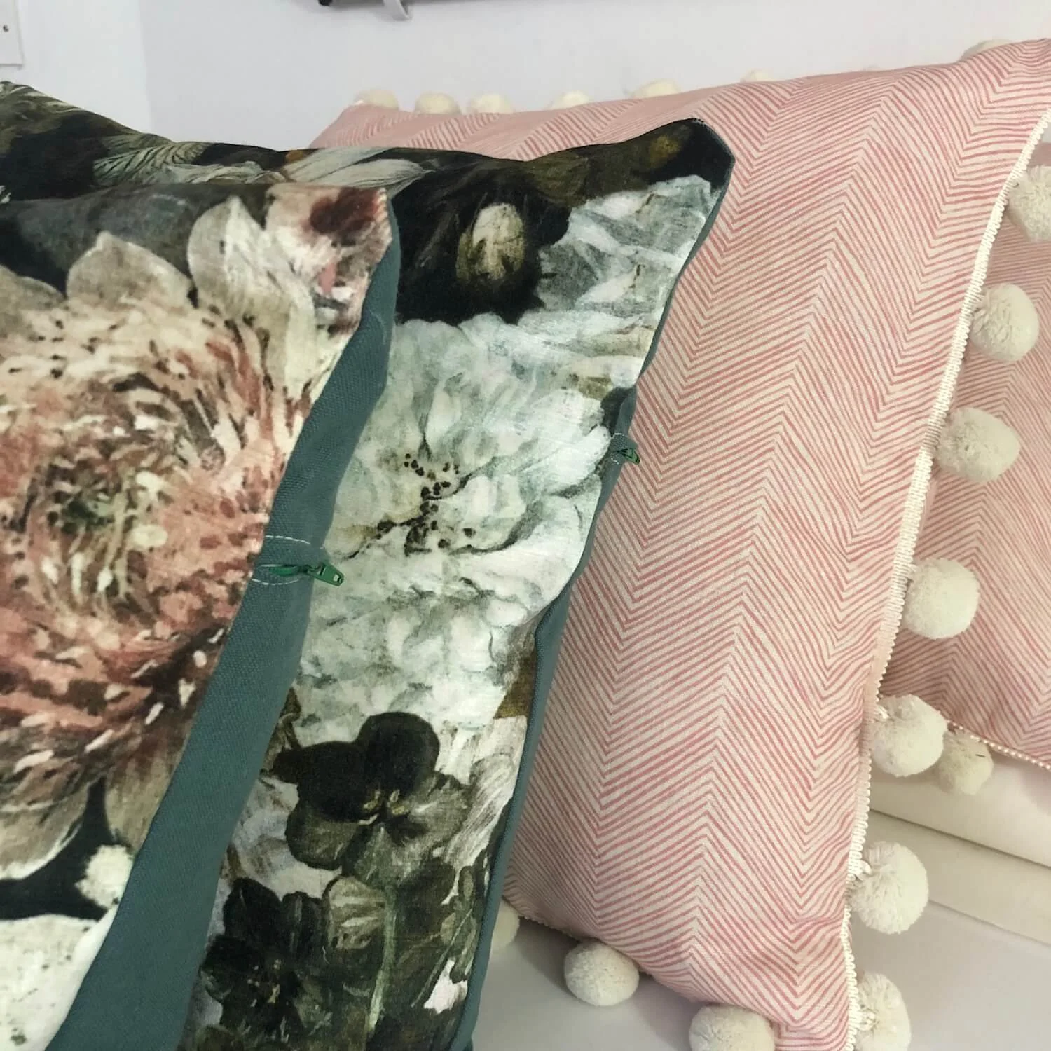 Close-up of pom-pom trimmed cushion with floral print