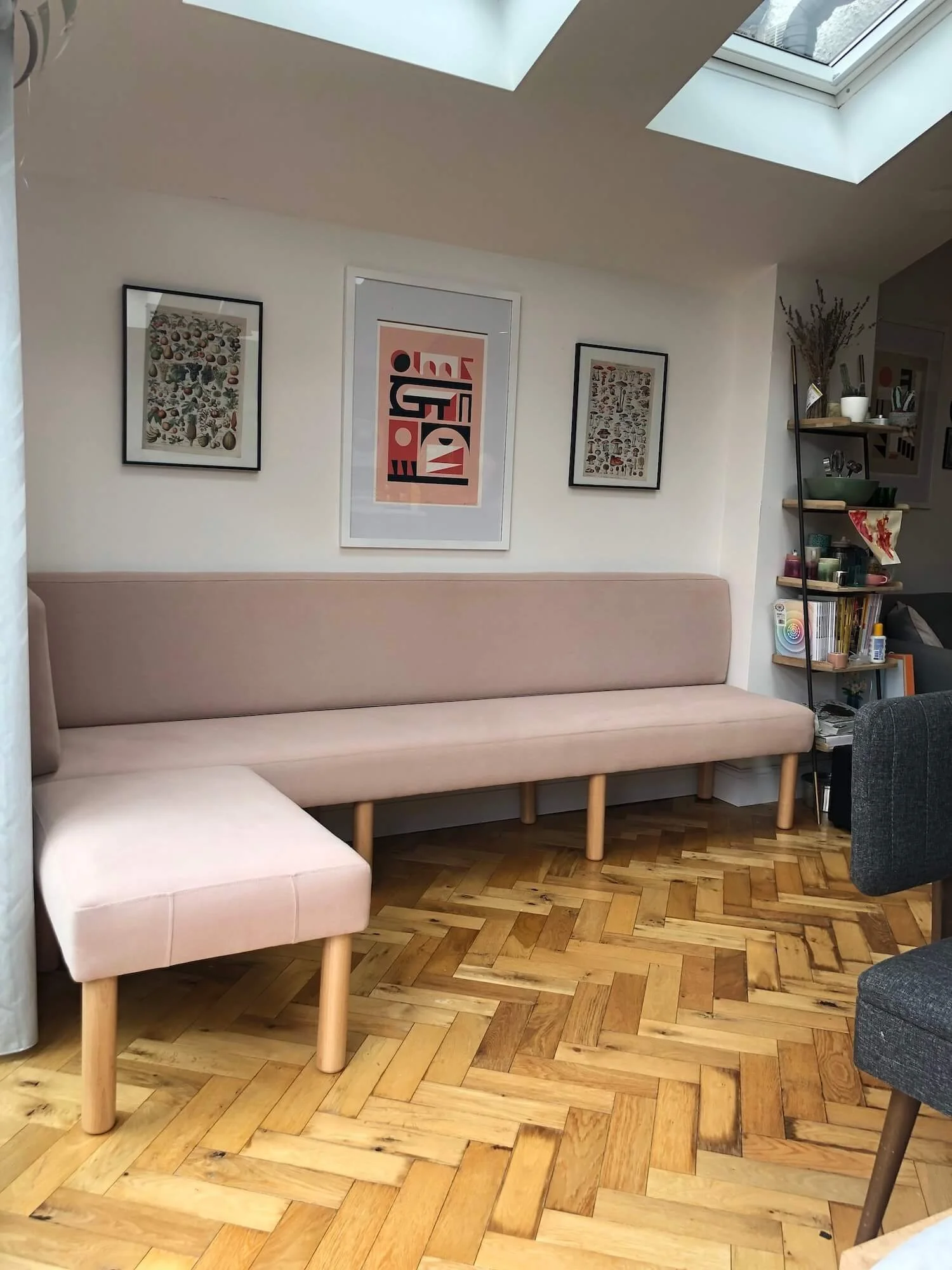 Long pink banquette in dining area with herringbone parquet floor