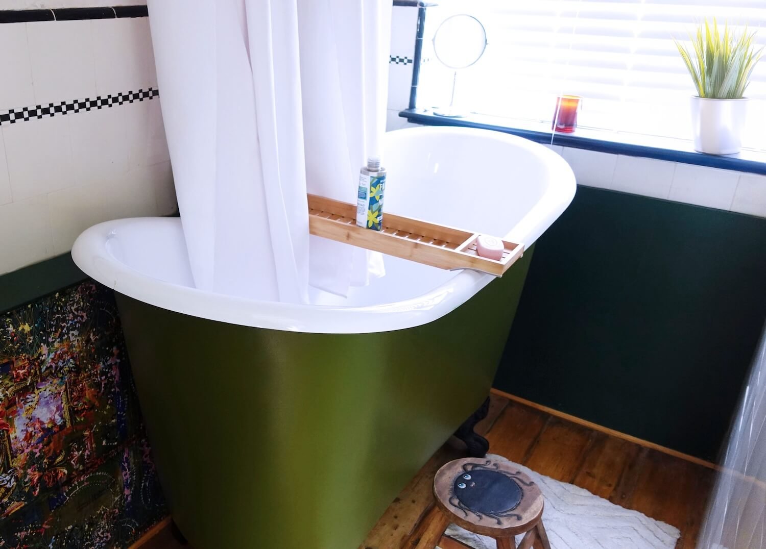 Bathroom with green freestanding bath and soft white  shower curtain