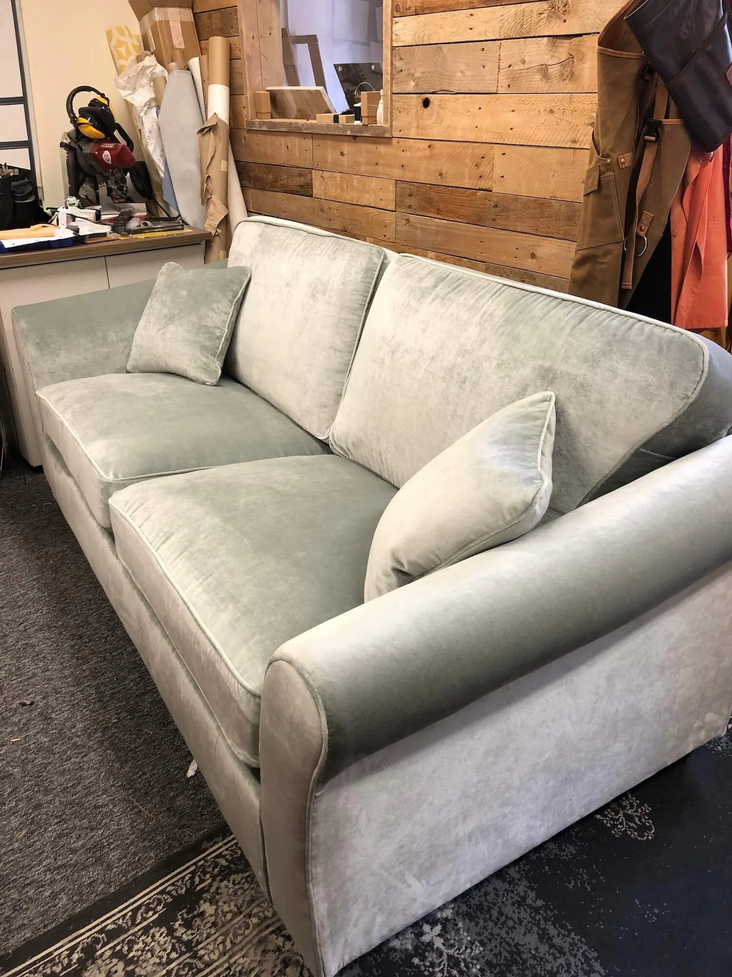 Sofa reupholstered in soft sage green velvet with matching cushions