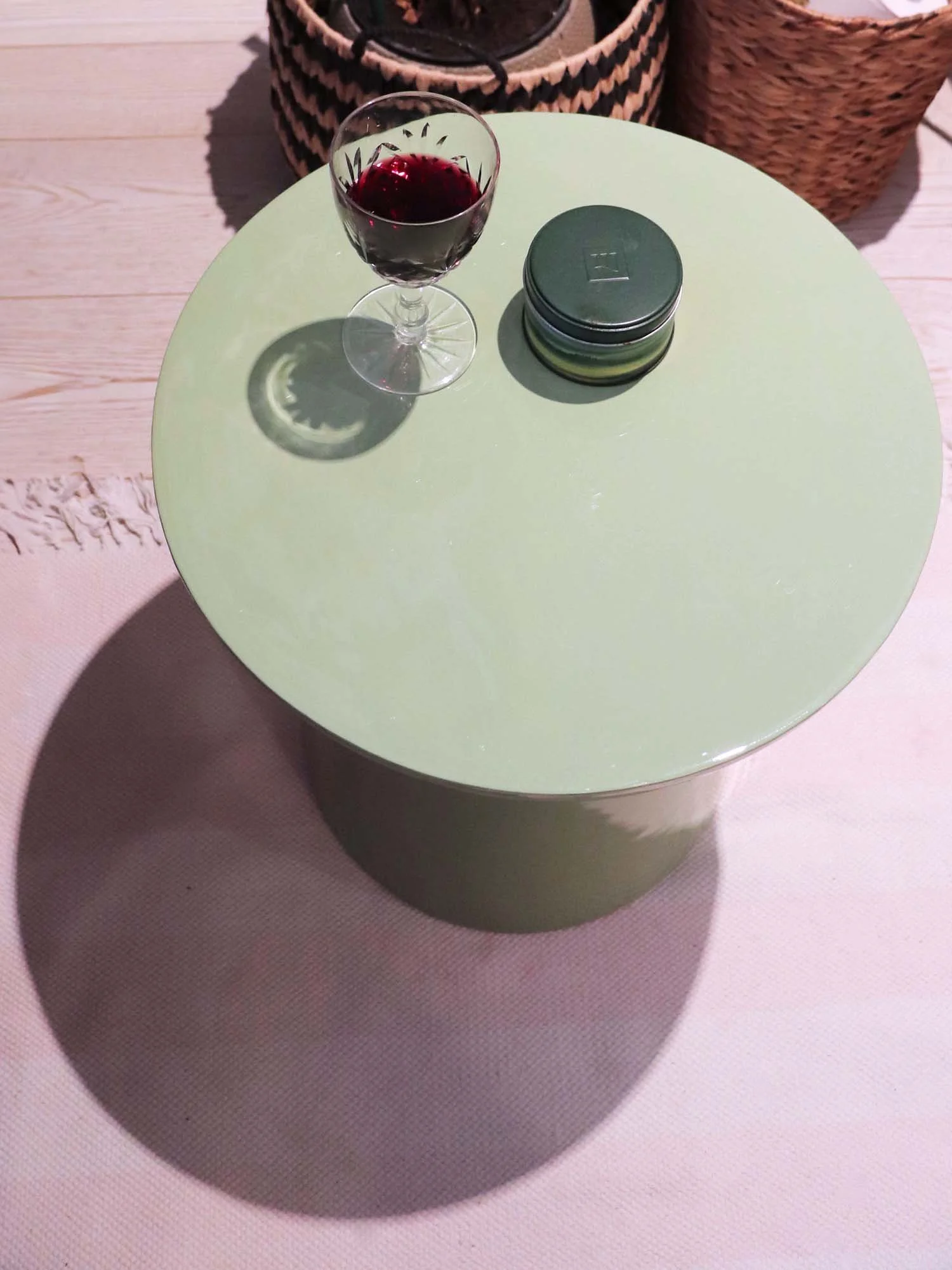 Top view of matcha green side table with wine glass and small candle pot