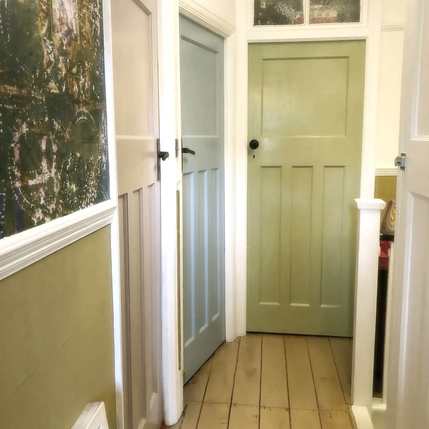 Hallway with colourful painted doors and patterned wallpaper