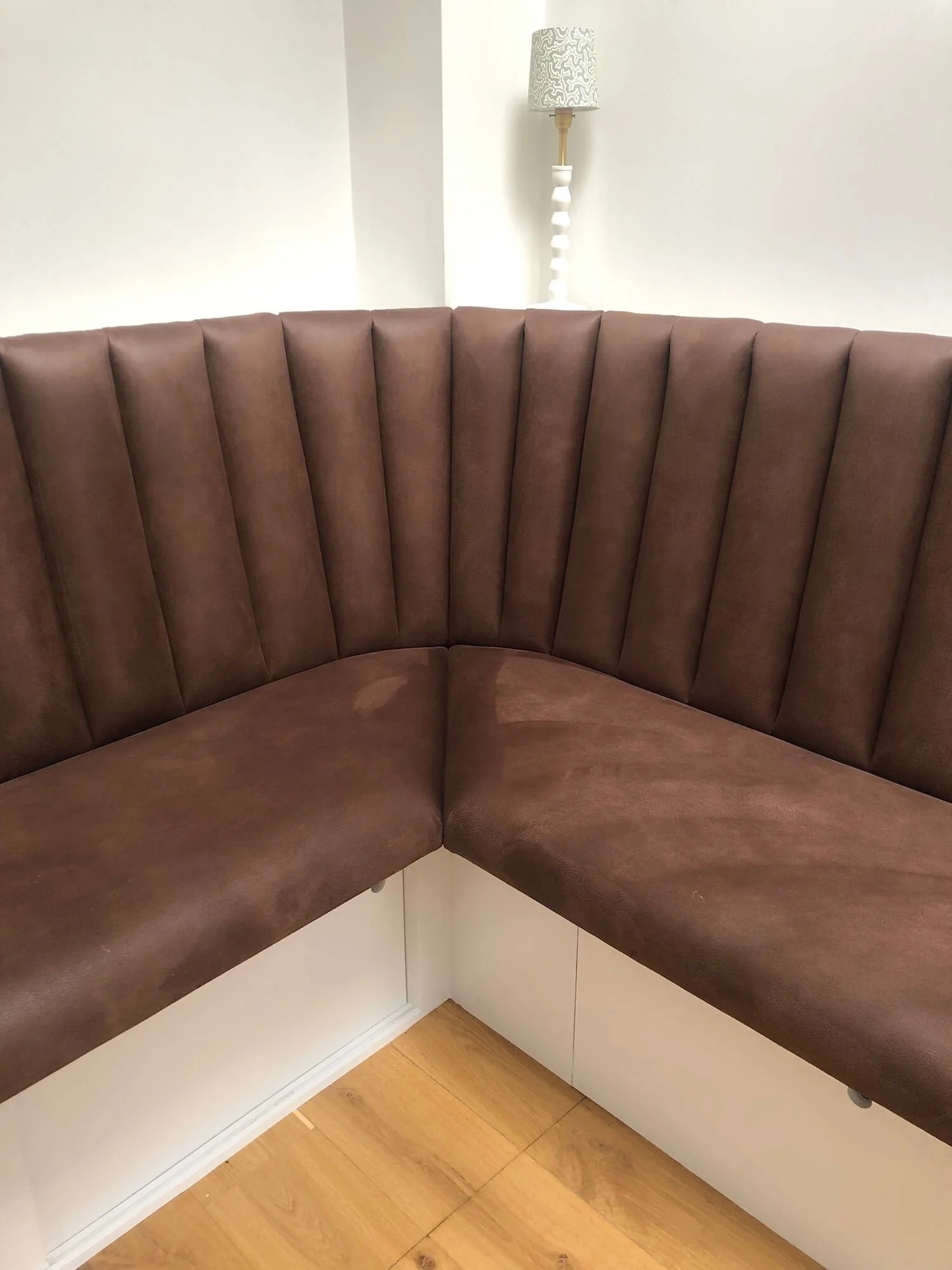 Bespoke corner banquette with fabric seat and under-bench storage drawers 
