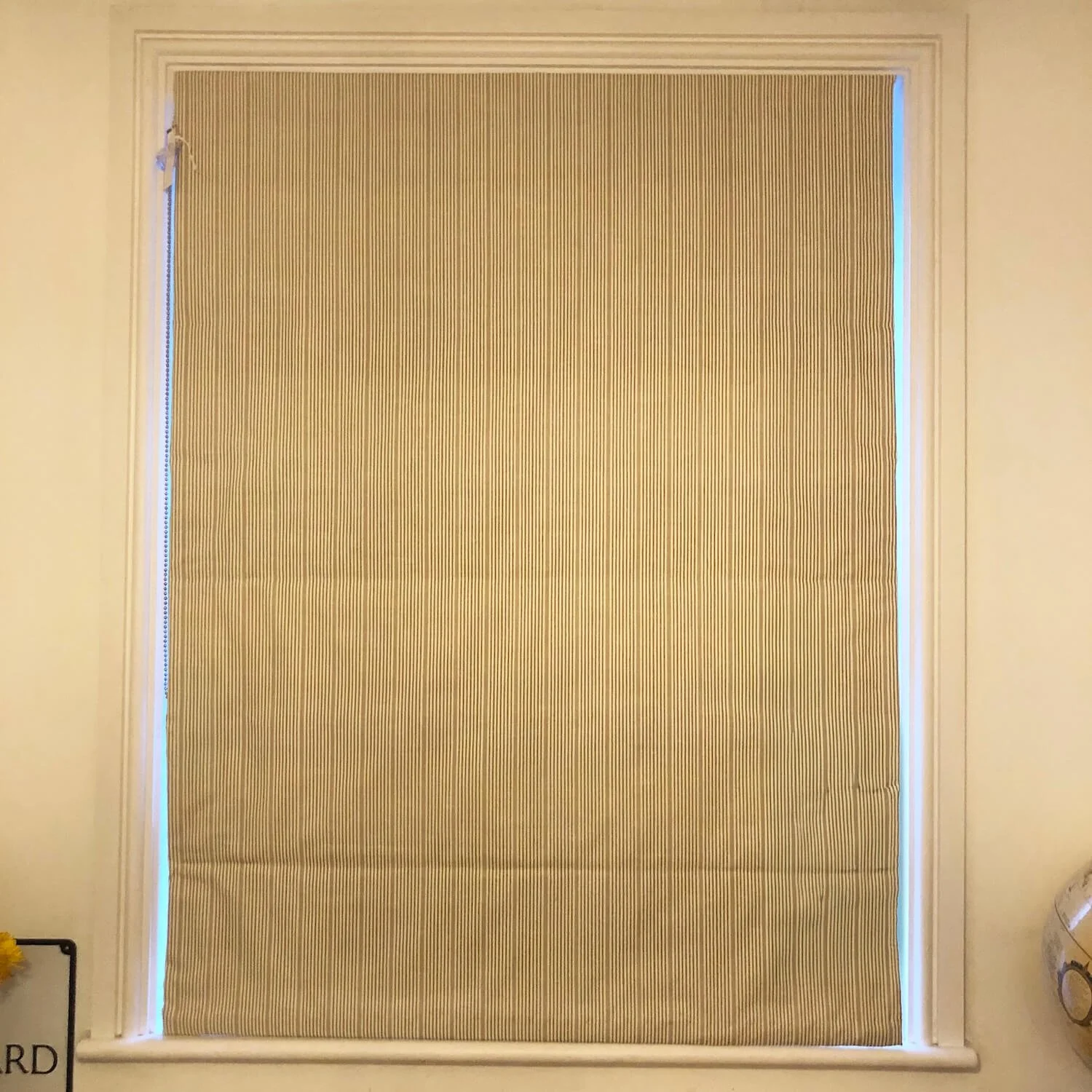 Textured Roman blind in soft neutral fabric in bedroom window