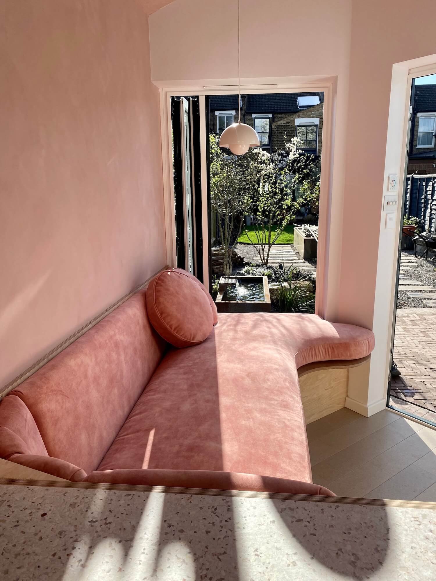 Blush pink curved bench cushion with vertical panelled backrest
