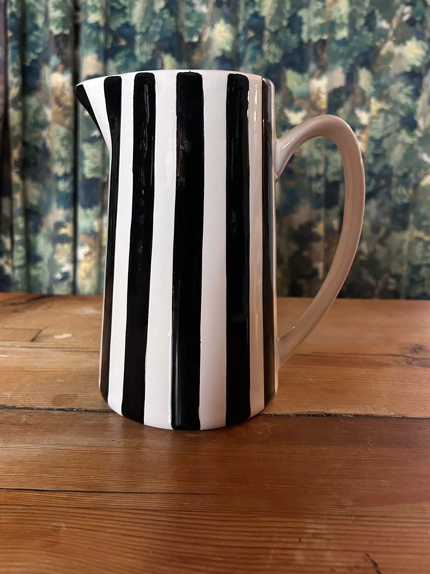 Black and white striped ceramic jug on wooden table