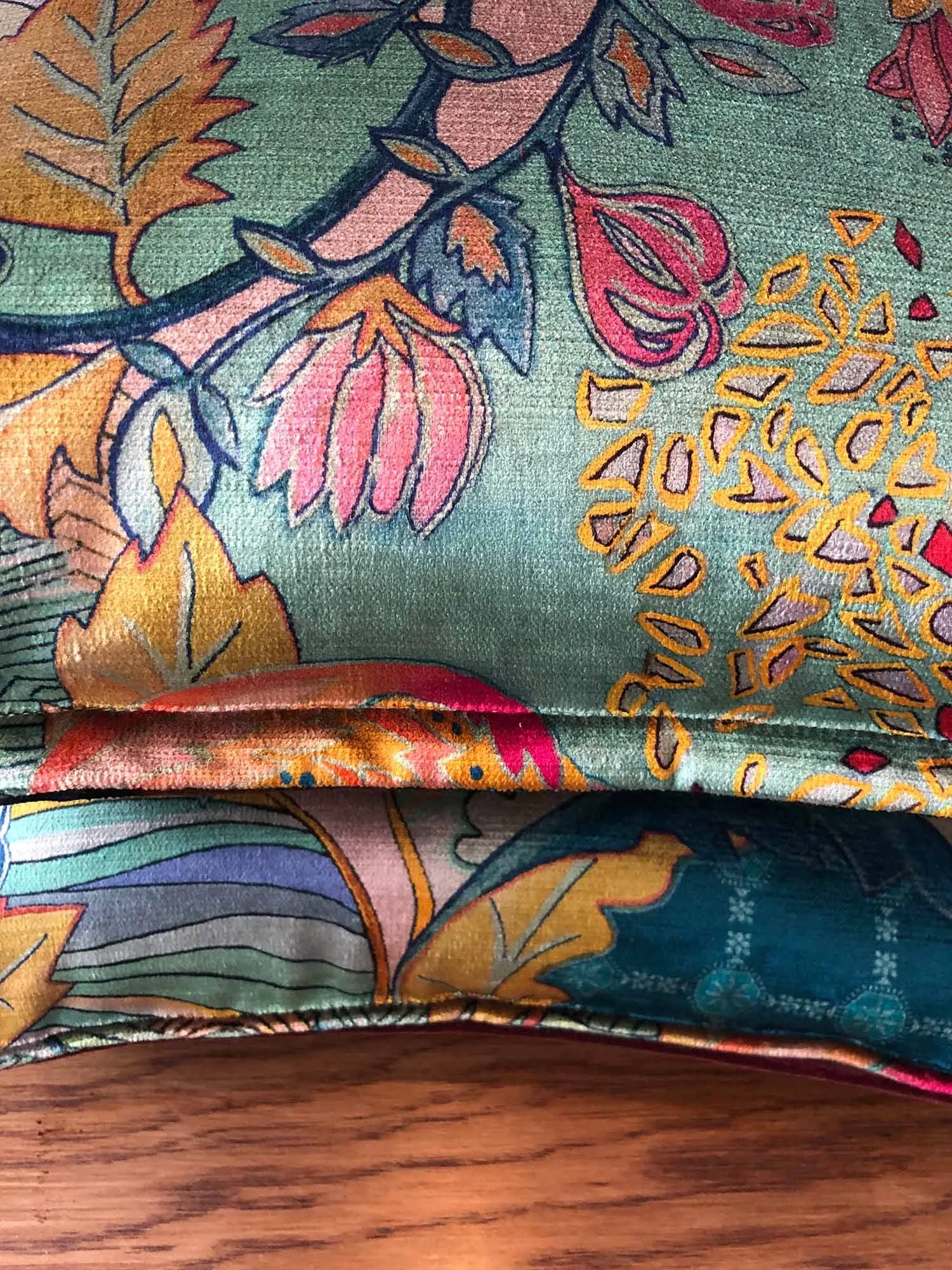 cushion edge of Mansfield Park Hartfield fabric showing teal background and multicolour florals