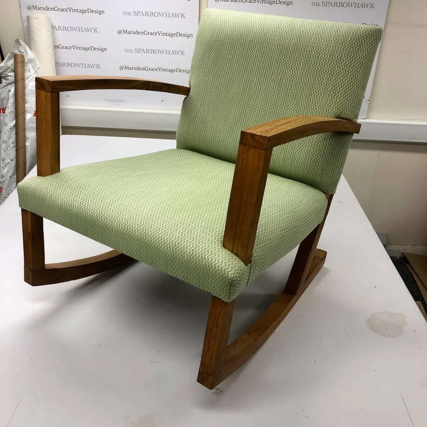 Contemporary armchair reupholstered in fresh green fabric with wooden arms