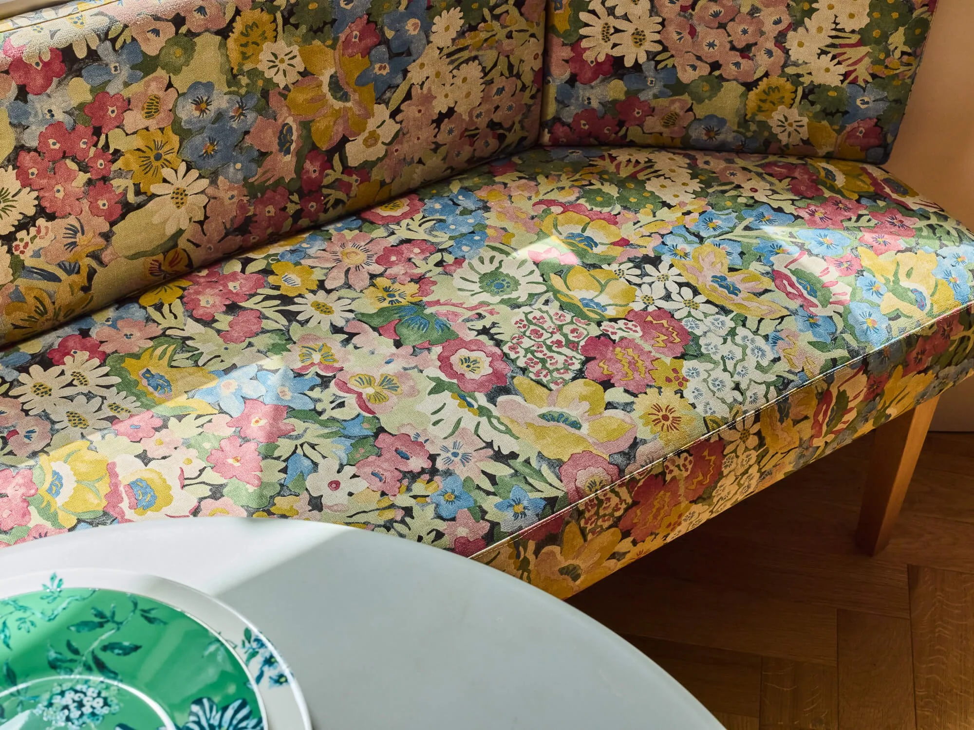 Floral upholstered banquette with colourful fabric, bespoke seating, cosy breakfast nook.