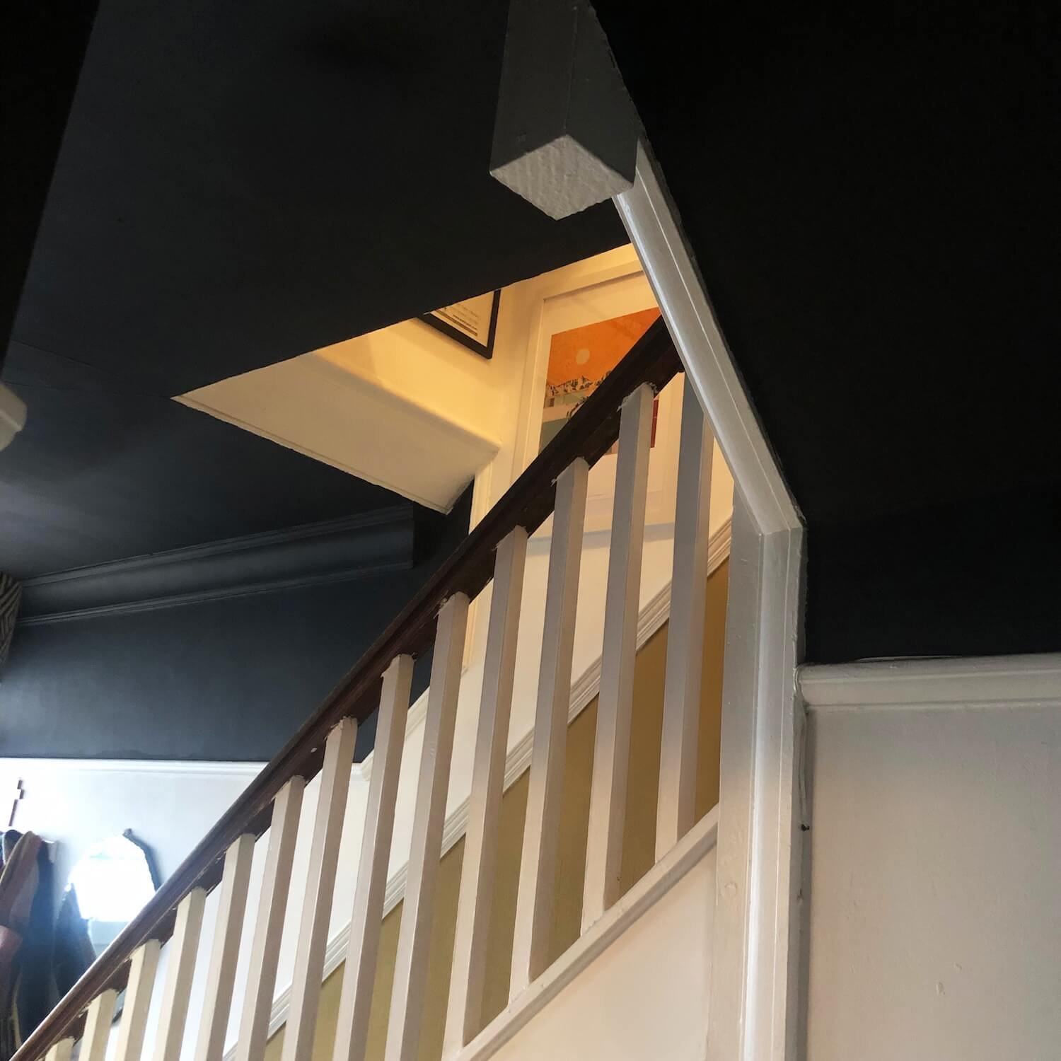 Staircase with striking dark coloured painted ceiling