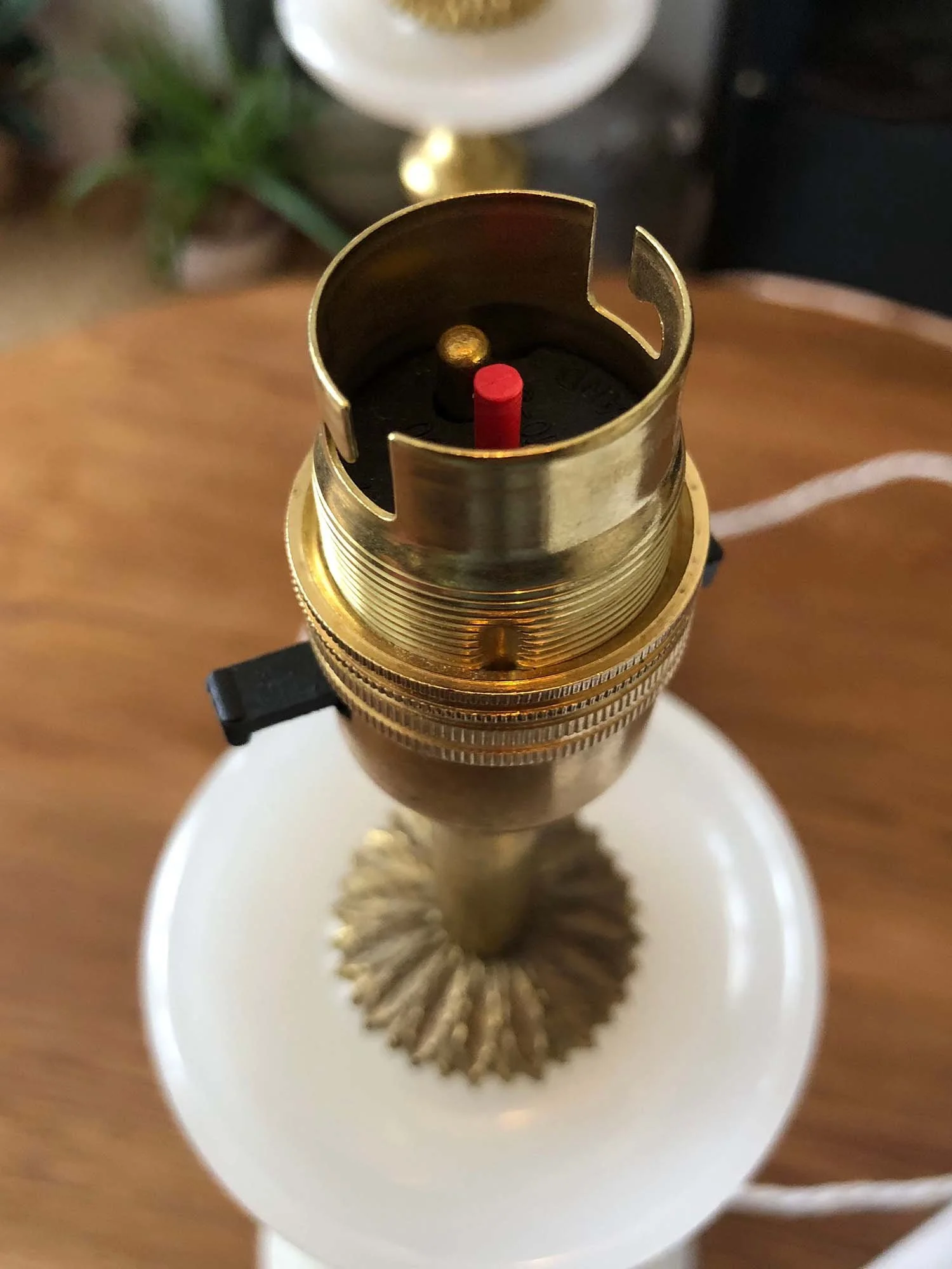 Close-up of brass bulb holder on vintage marble lamp base