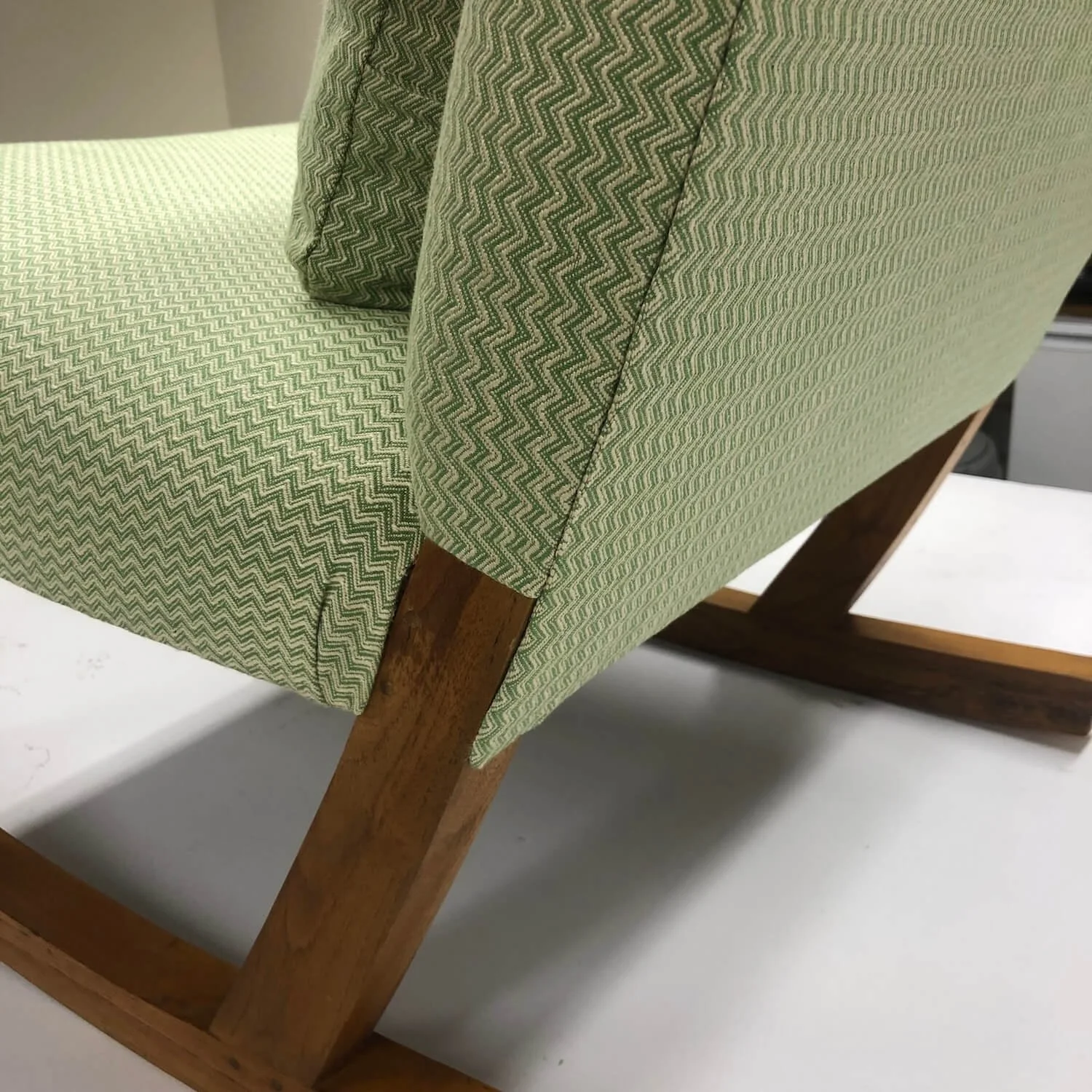 Close-up of green textured upholstery on restored armchair