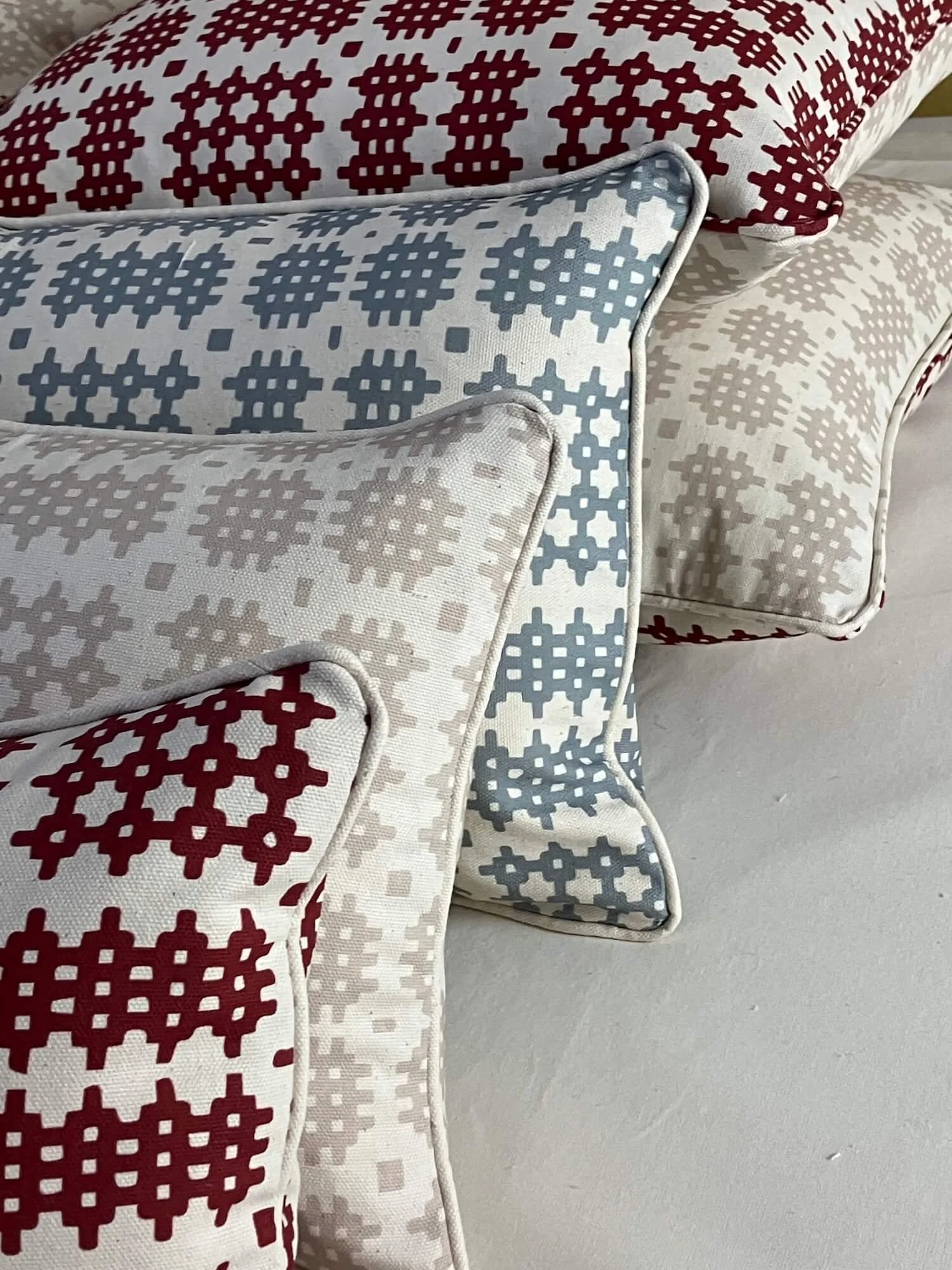 Collection of patterned cushions in red, blue and grey designs
