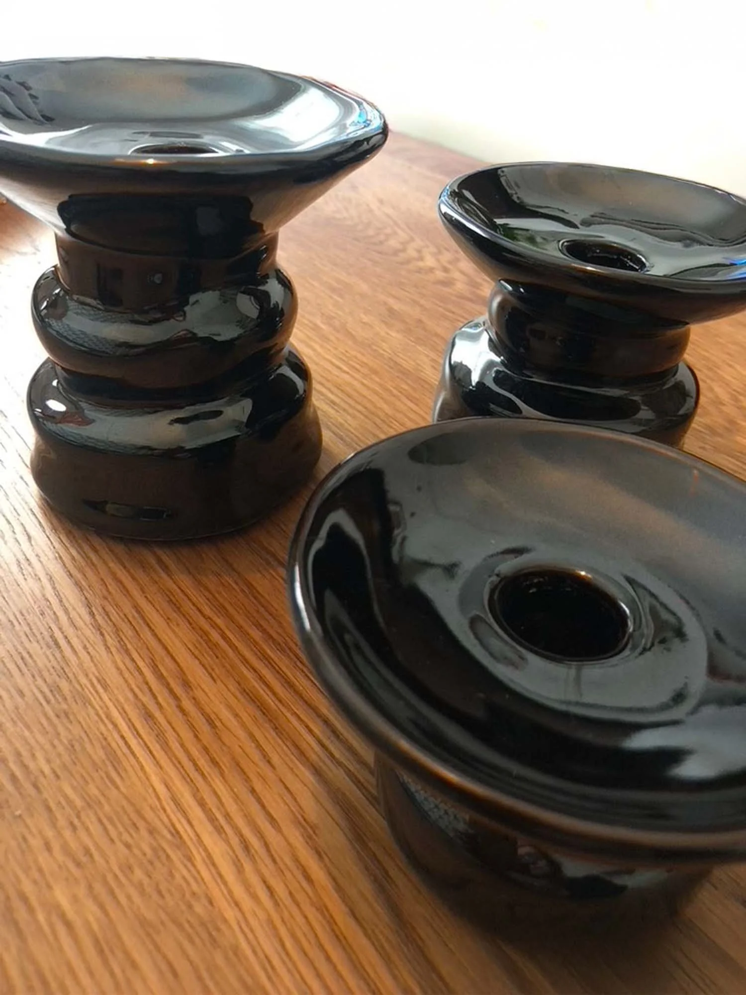 Black Padre earthenware candle holders displayed on wooden surface