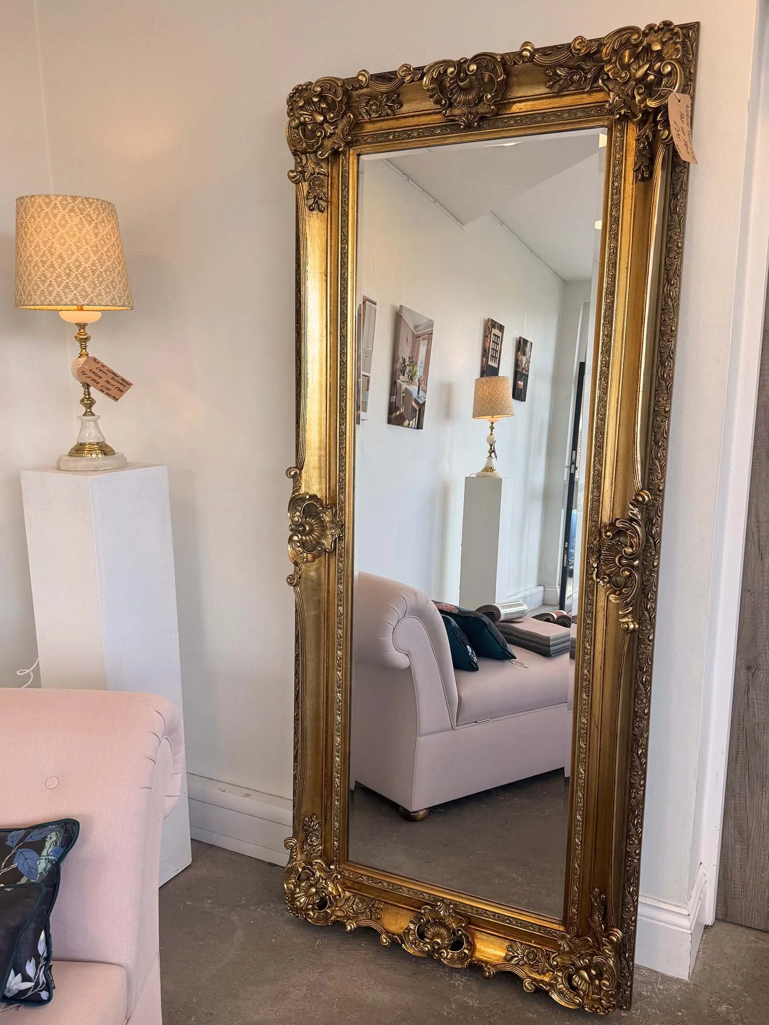 Tall Antique Style Mirror in the showroom with a chase and a vintage light
