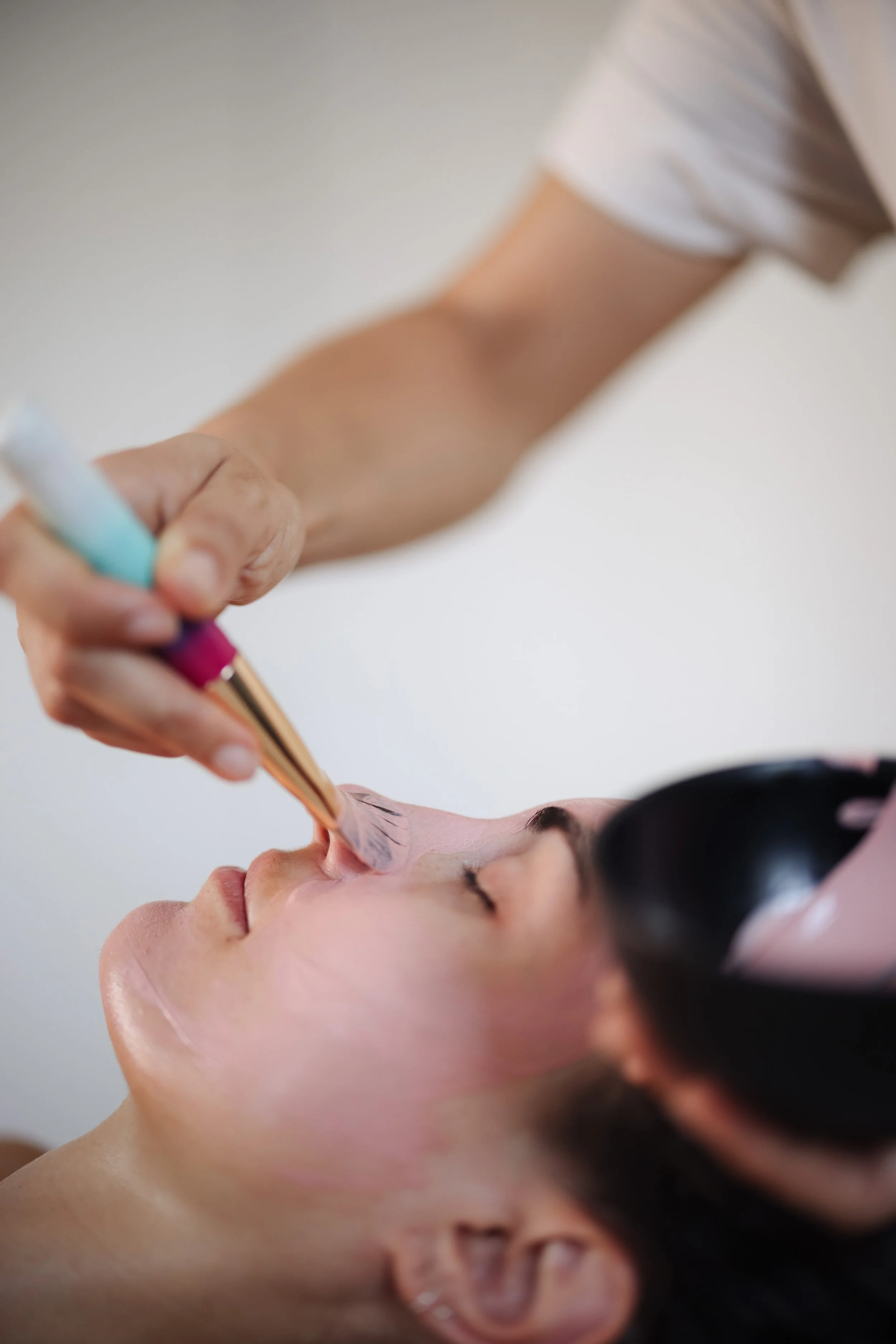 Nina Wrodnigg bekommt von Lena Carrera eine Gesichtsmaske mit einem Pinsel aufgetragen.