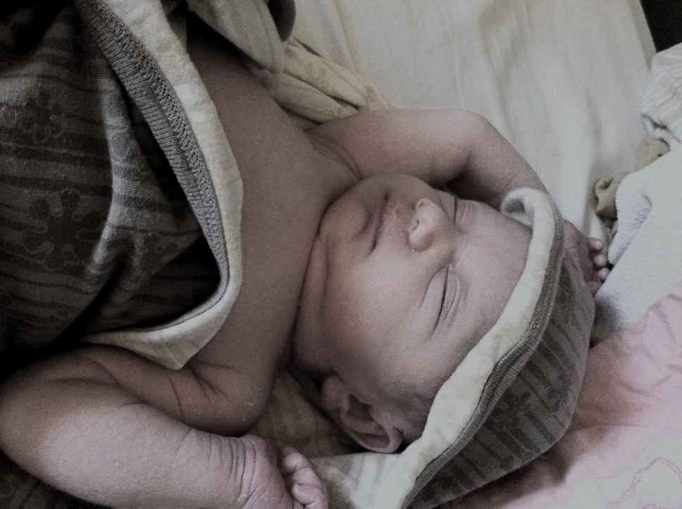 An infant is swaddled in blankets