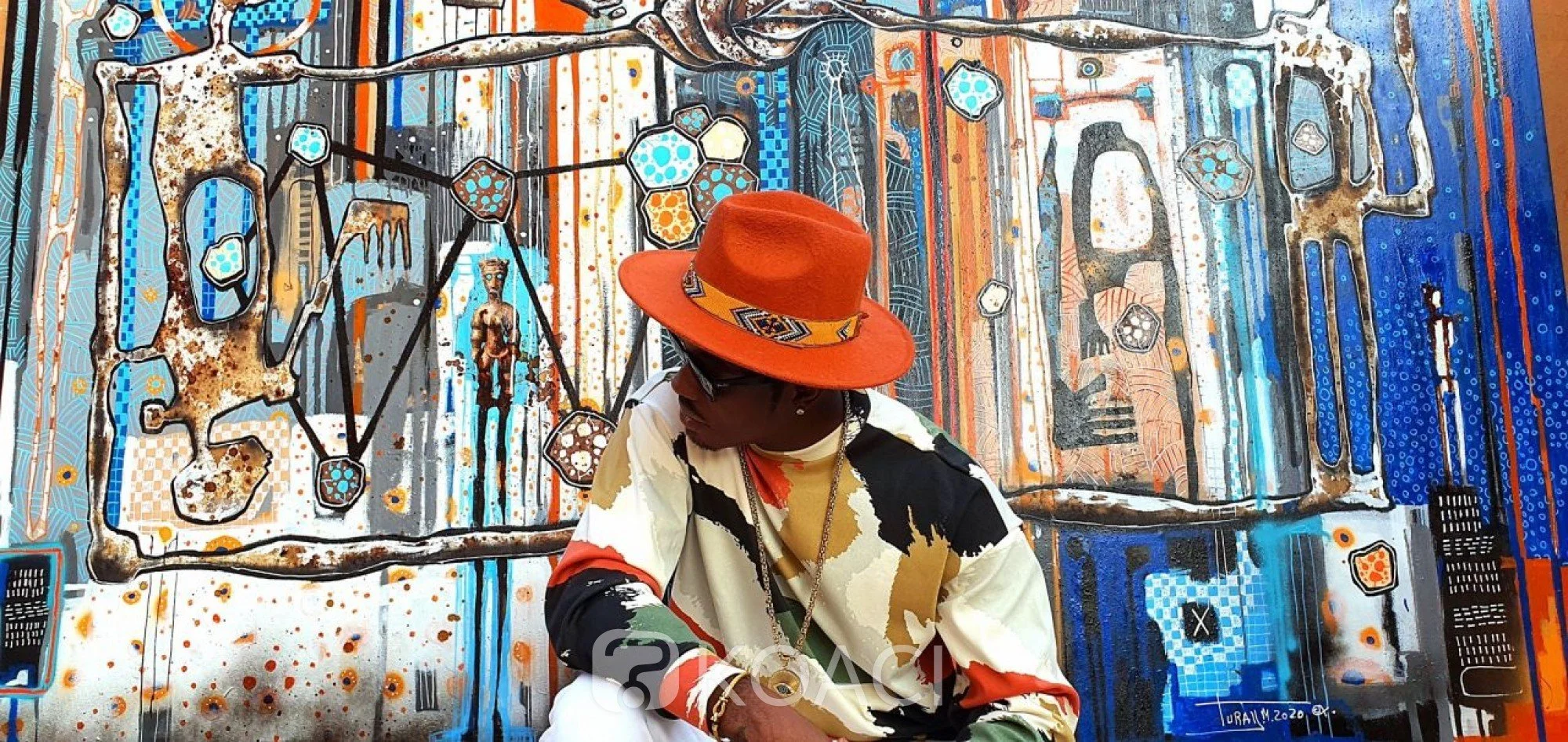 Mederic Turay, african painetr and artsist in front of original african contemporary painting