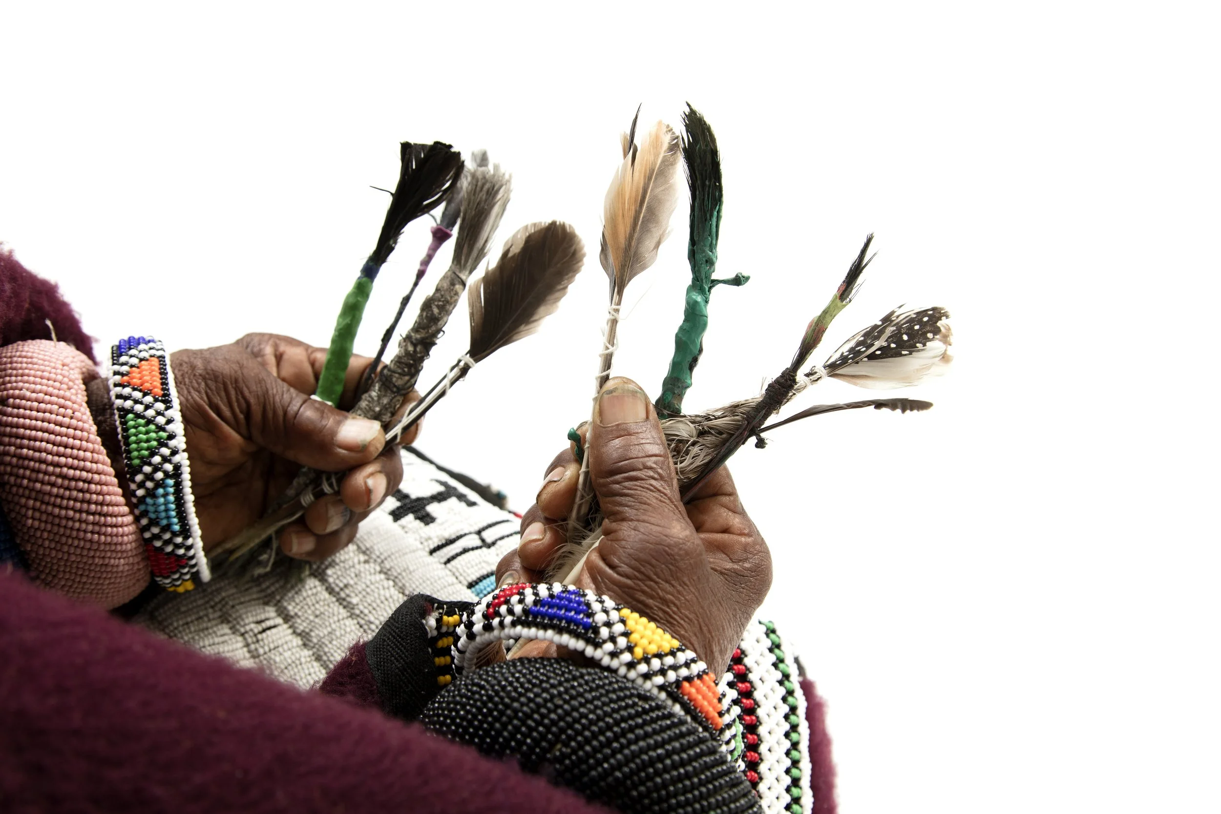 Dr. Esther Mahlangu in her studi with feathers to paint original Ndebele painting