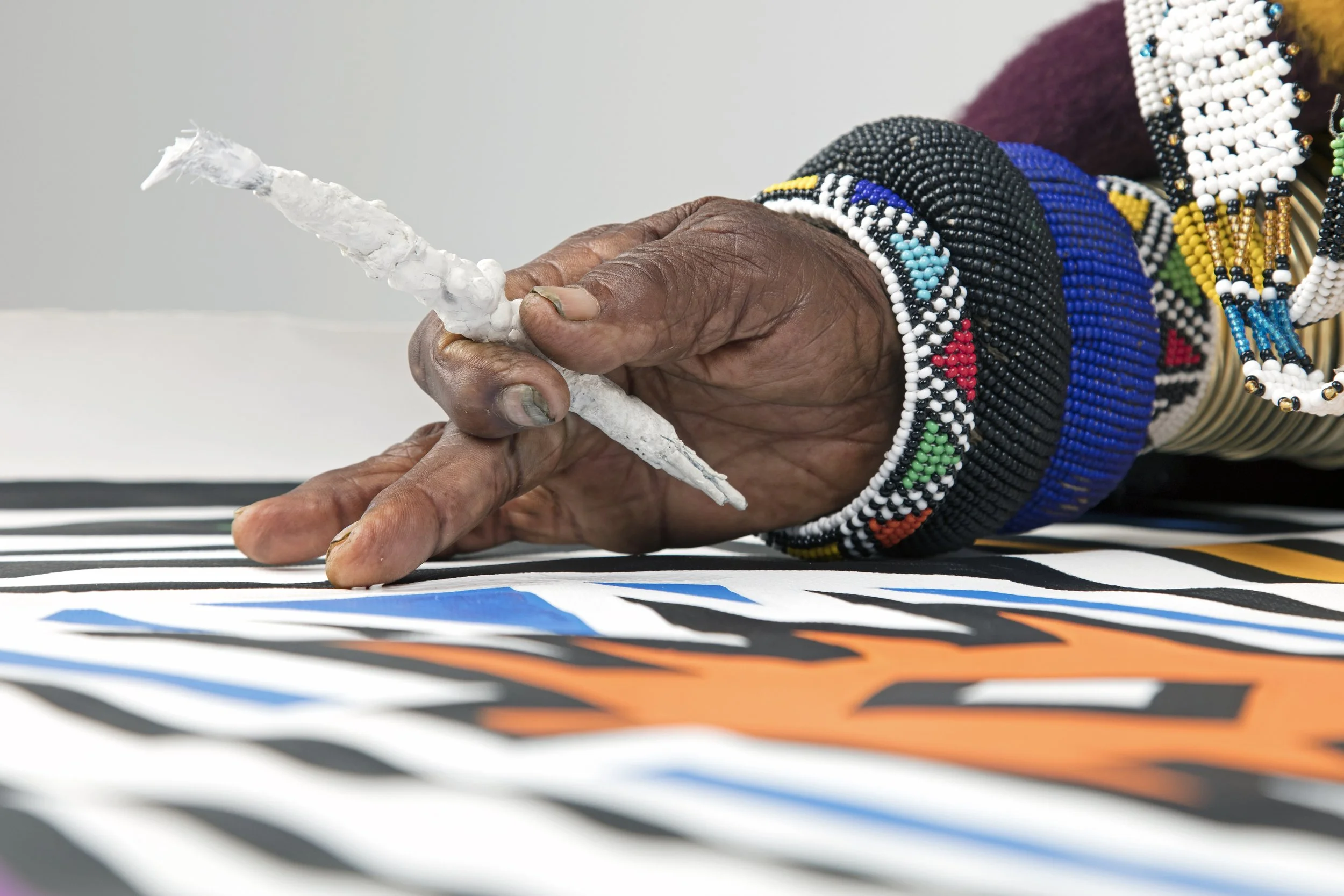 Dr. Esther Mahlangu painting an original Ndebele artwork