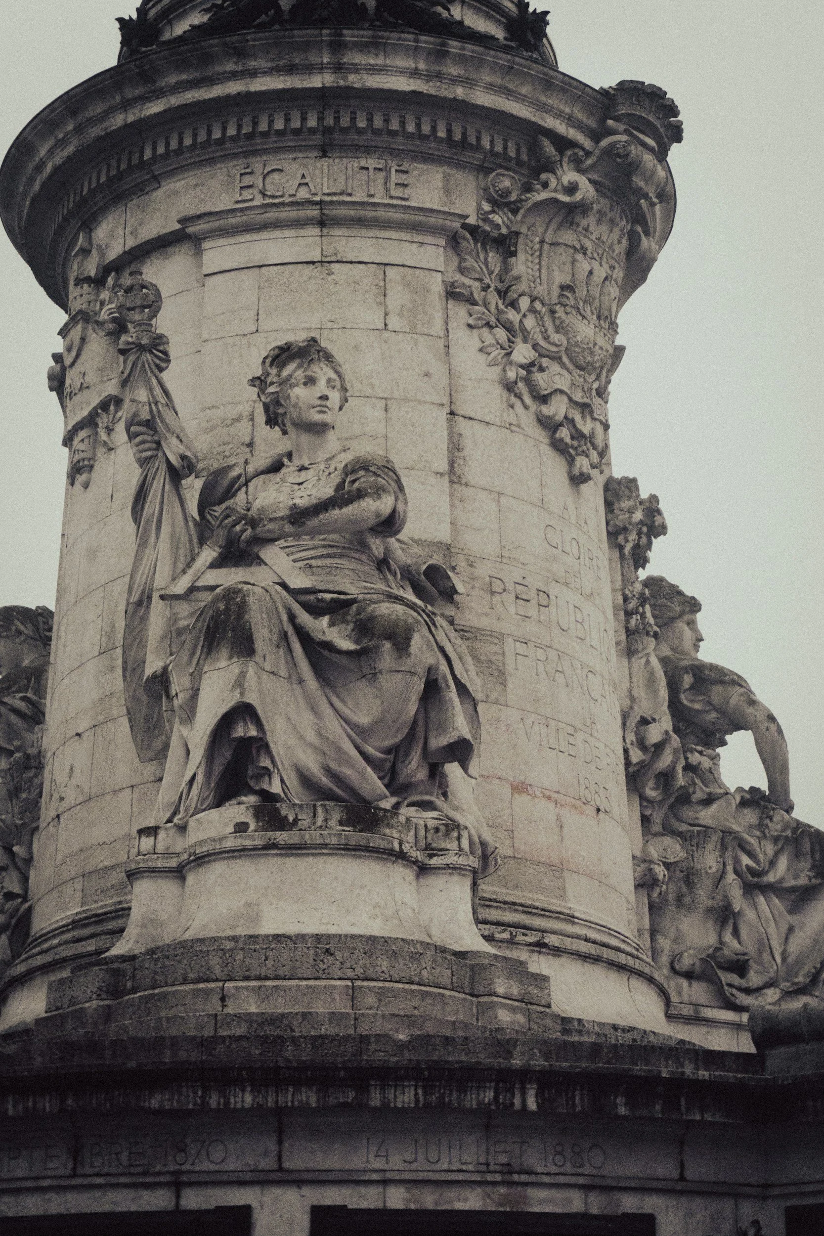A close-up of a detailed stone monument with sculptures and inscriptions, including the word 'ÉGALITÉ' at the top.