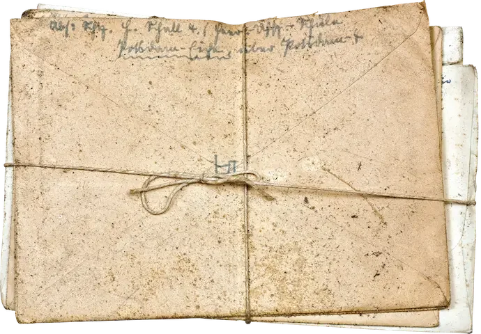 Old, worn, handwritten documents or papers bundled together with string.