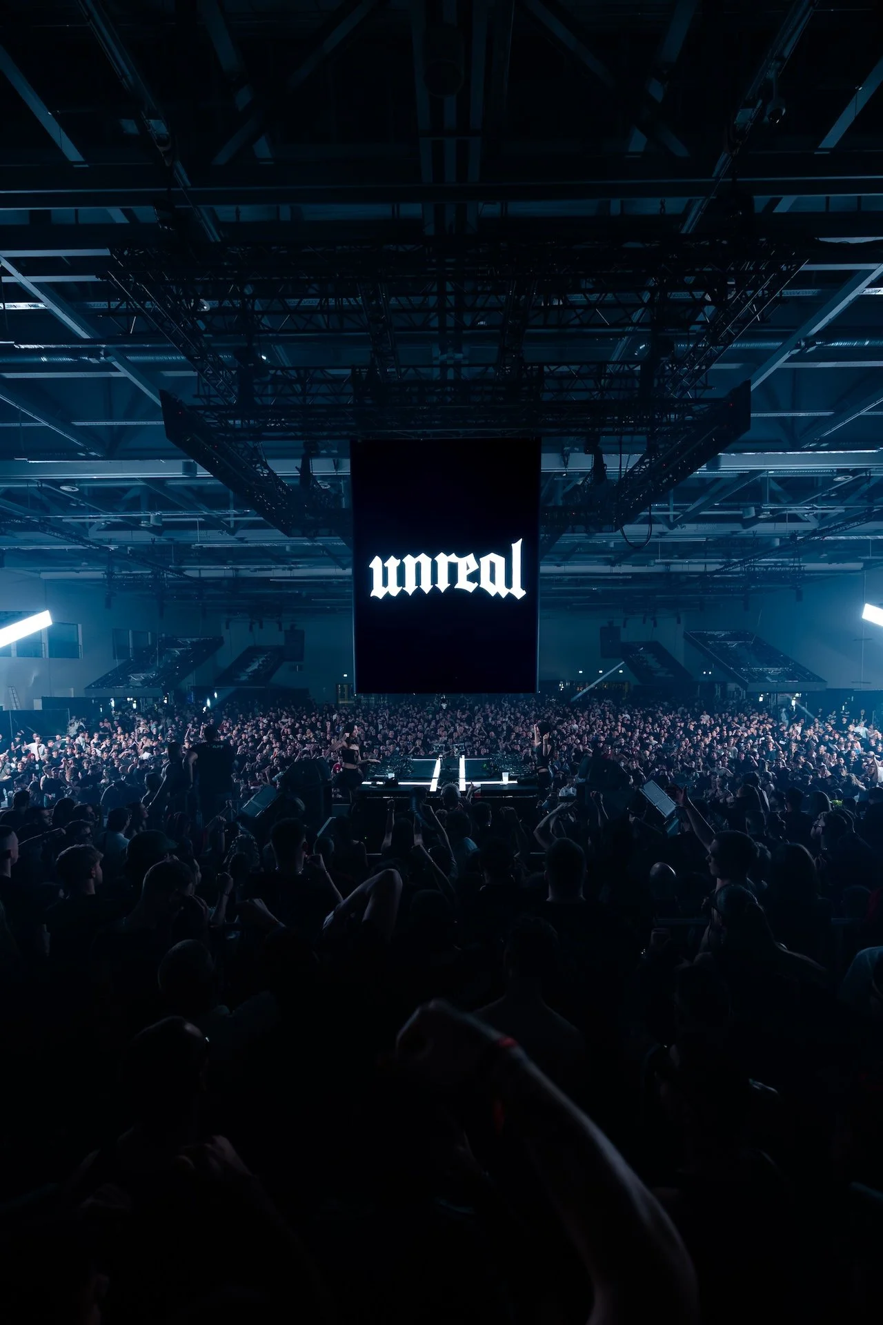 huge arena crowded with a lot of people at a rave