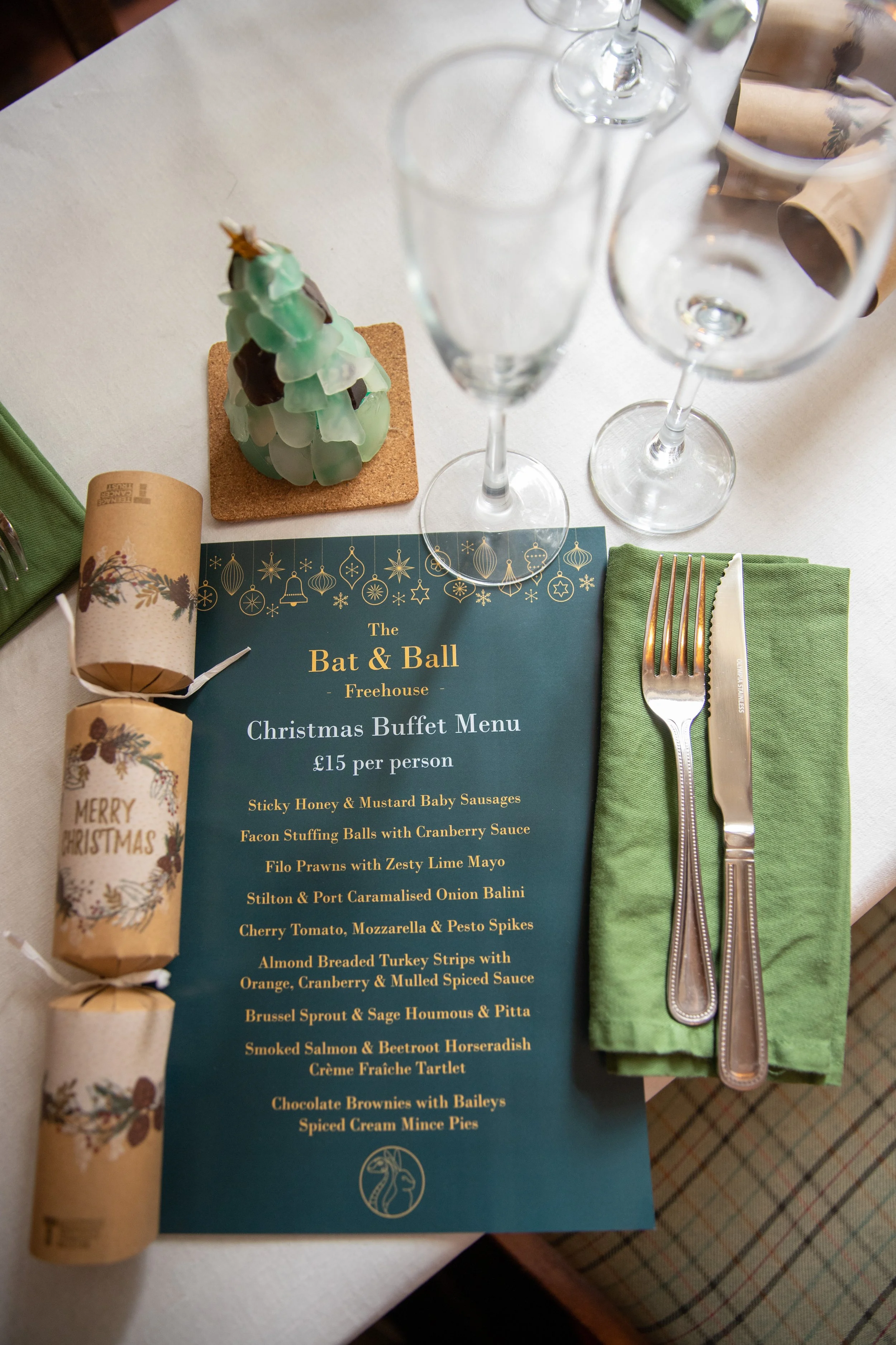 Christmas buffet menu at The Bat & Ball Freehouse with holiday decorations and cutlery on a table.