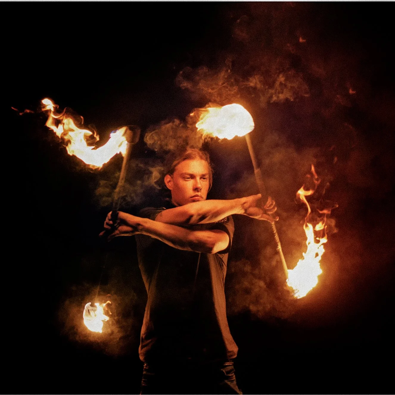 A professional performer skillfully spinning fire torches in the dark.