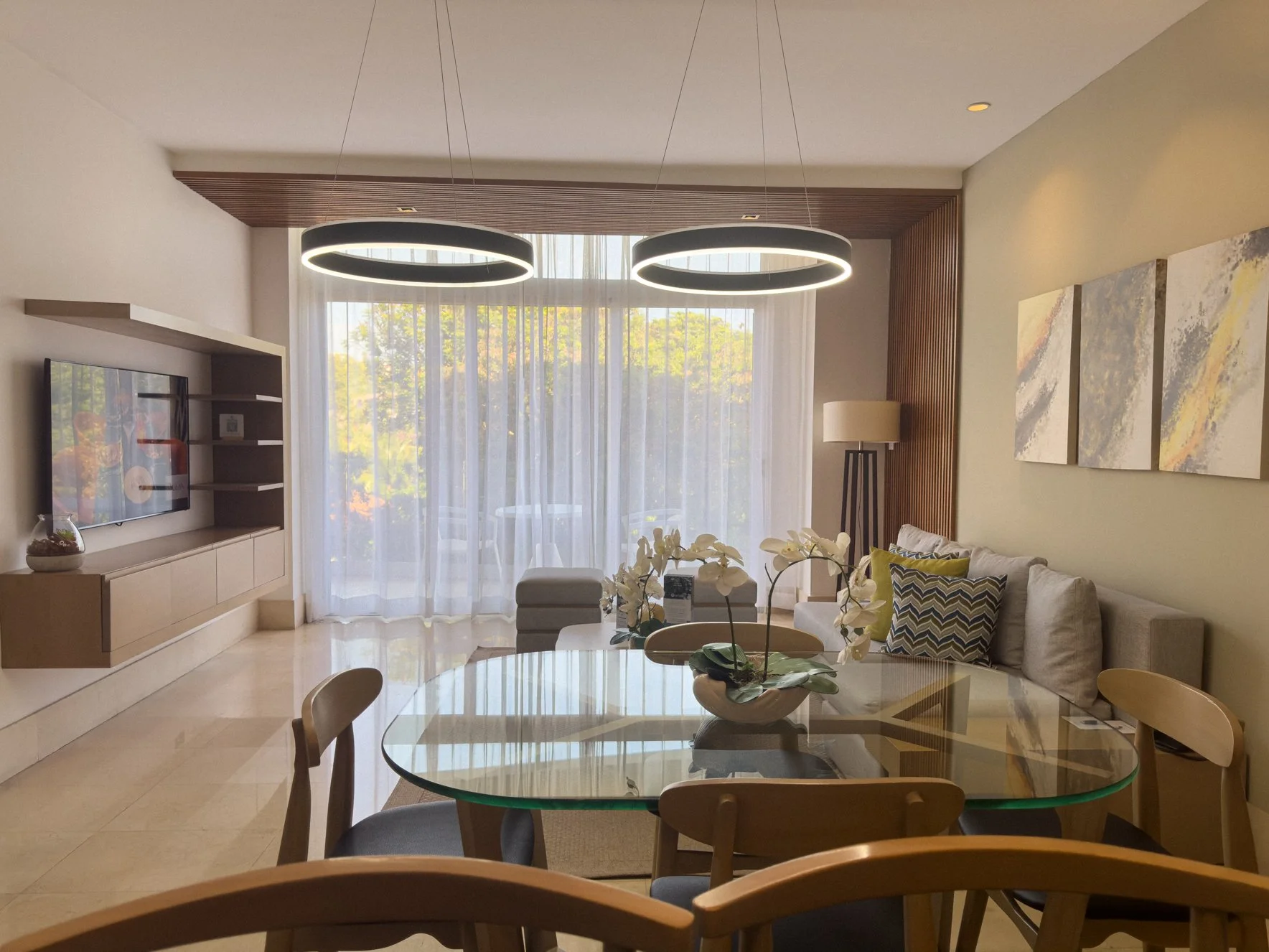 Bright living room with elegant glass table, stylish sofa, and large windows.