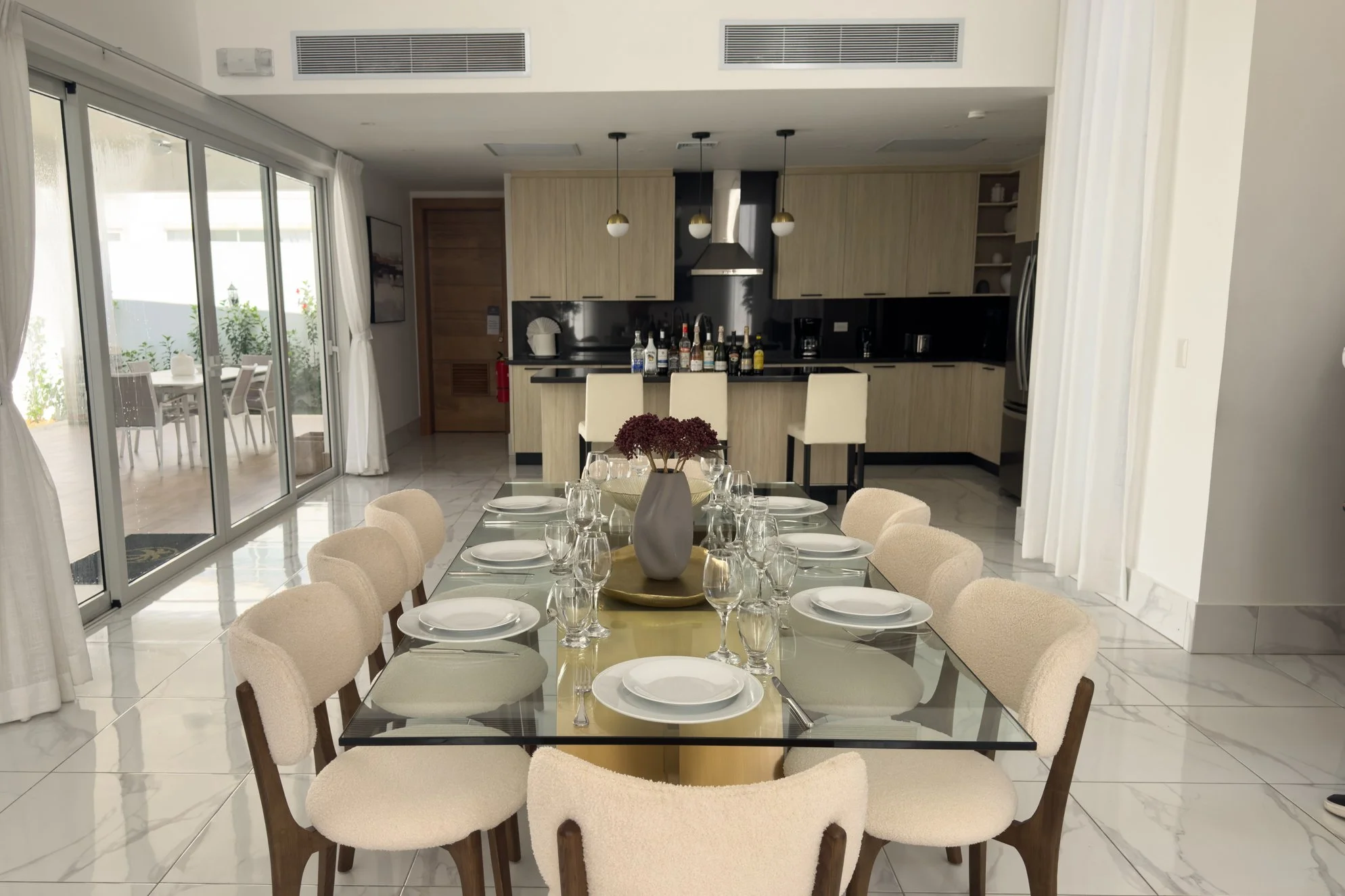 Elegant glass dining table and contemporary open kitchen for a premium stay.