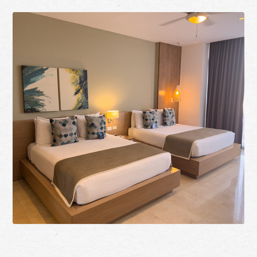 Premium suite featuring two comfortable beds, stylish wall art, and warm lighting.