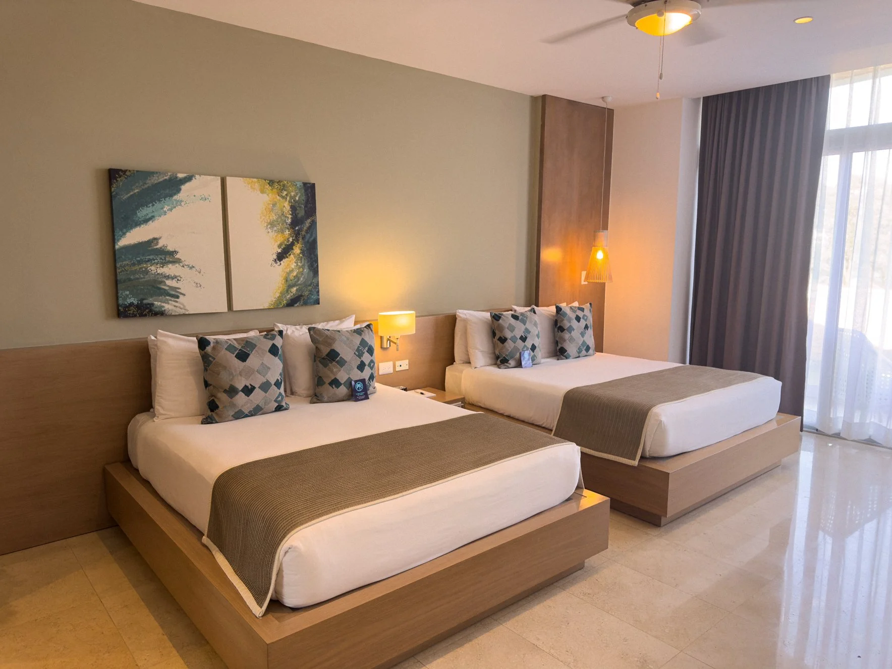 Premium suite featuring two comfortable beds, stylish wall art, and warm lighting.