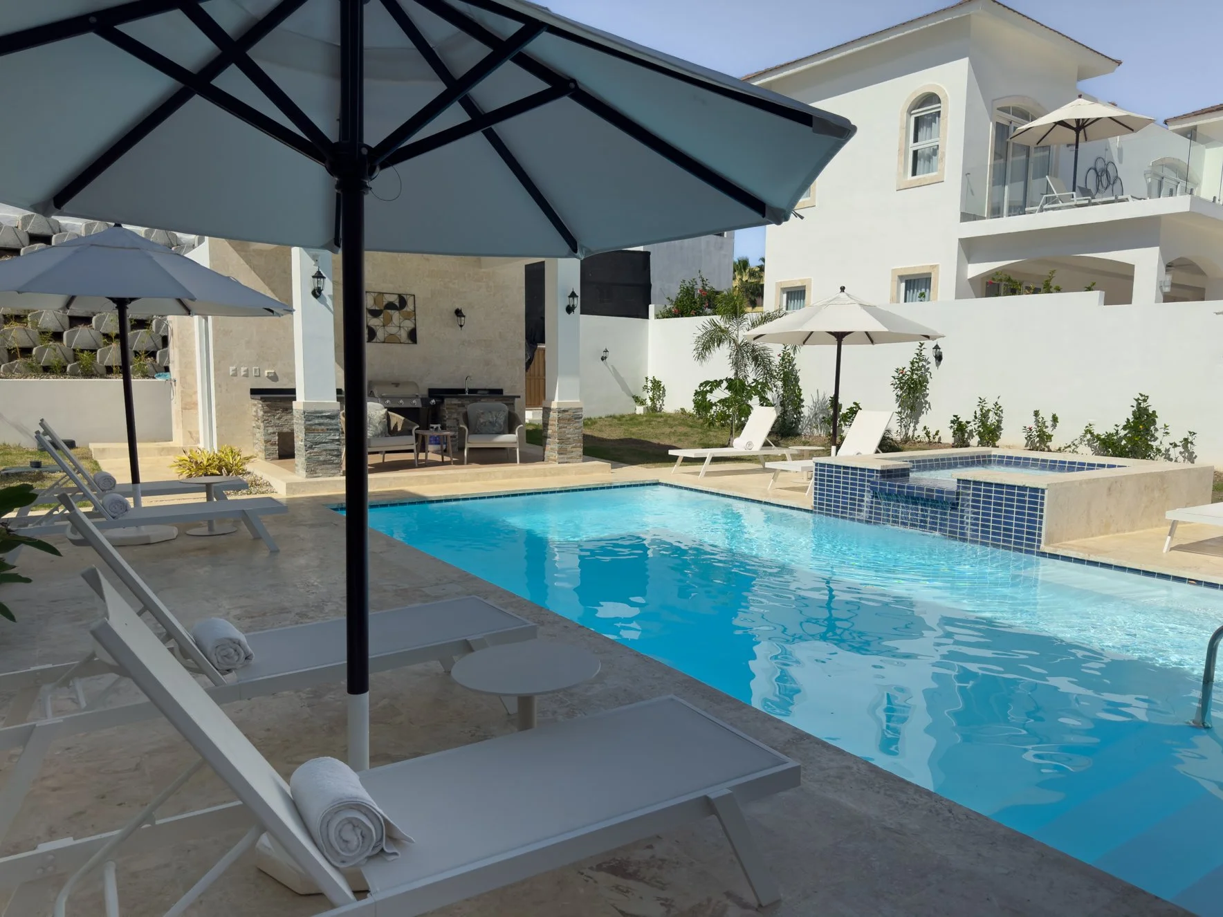 Outdoor luxury pool area with umbrellas and sunbeds for a relaxing escape.