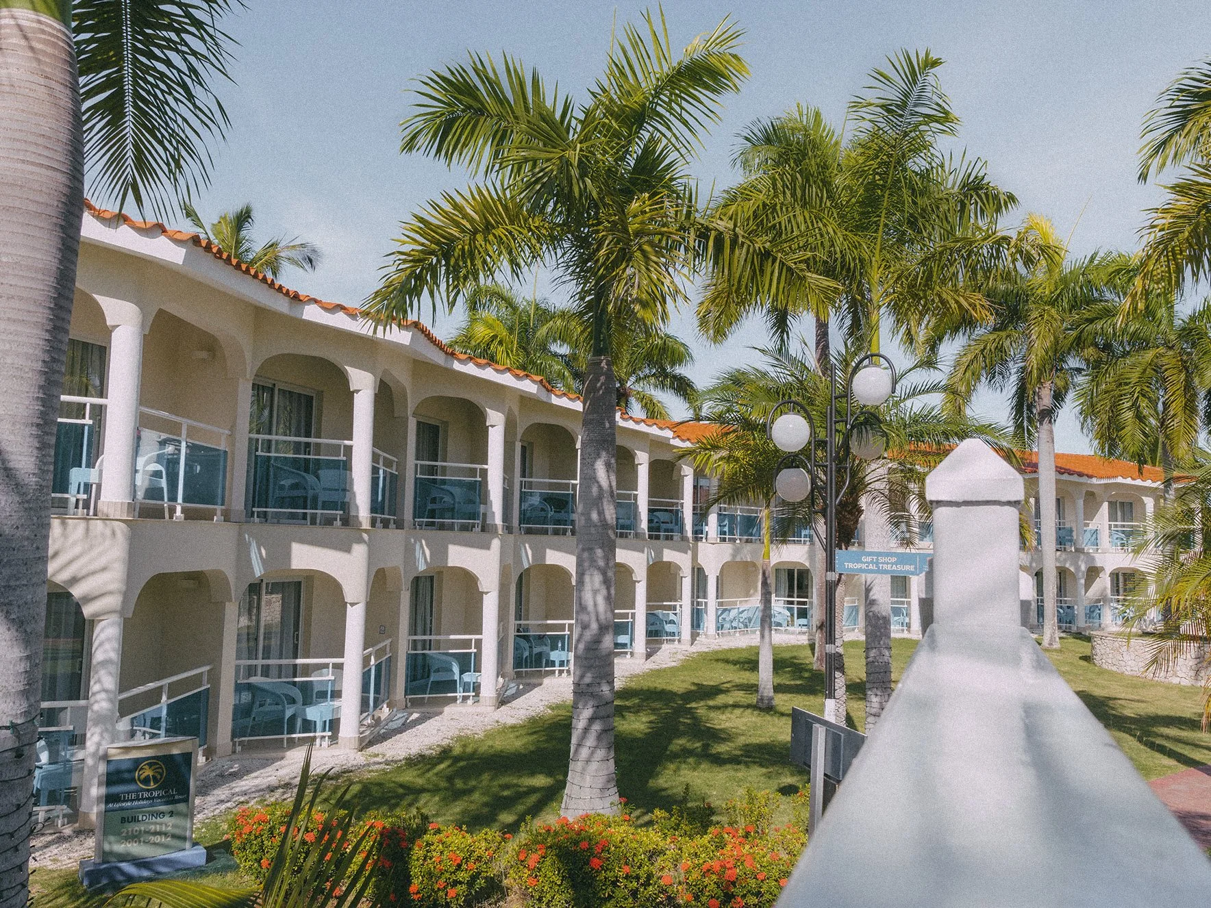 raditional two-story tropical architecture featuring white pillars, private balconies, and landscaped gardens.