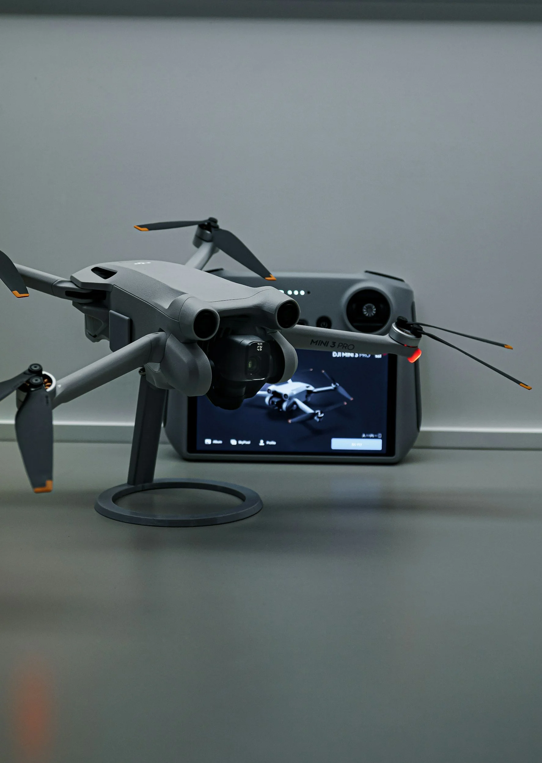 A drone set up on a table with its remote control and screen displaying the drone.