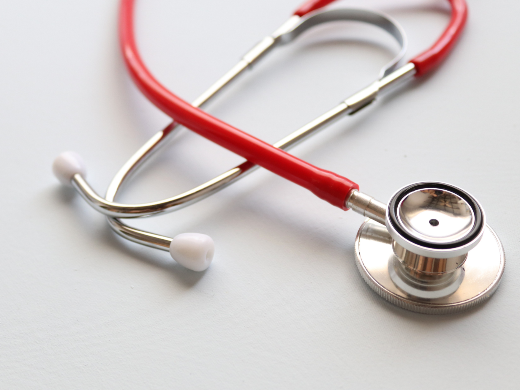 Red and silver stethoscope on white background