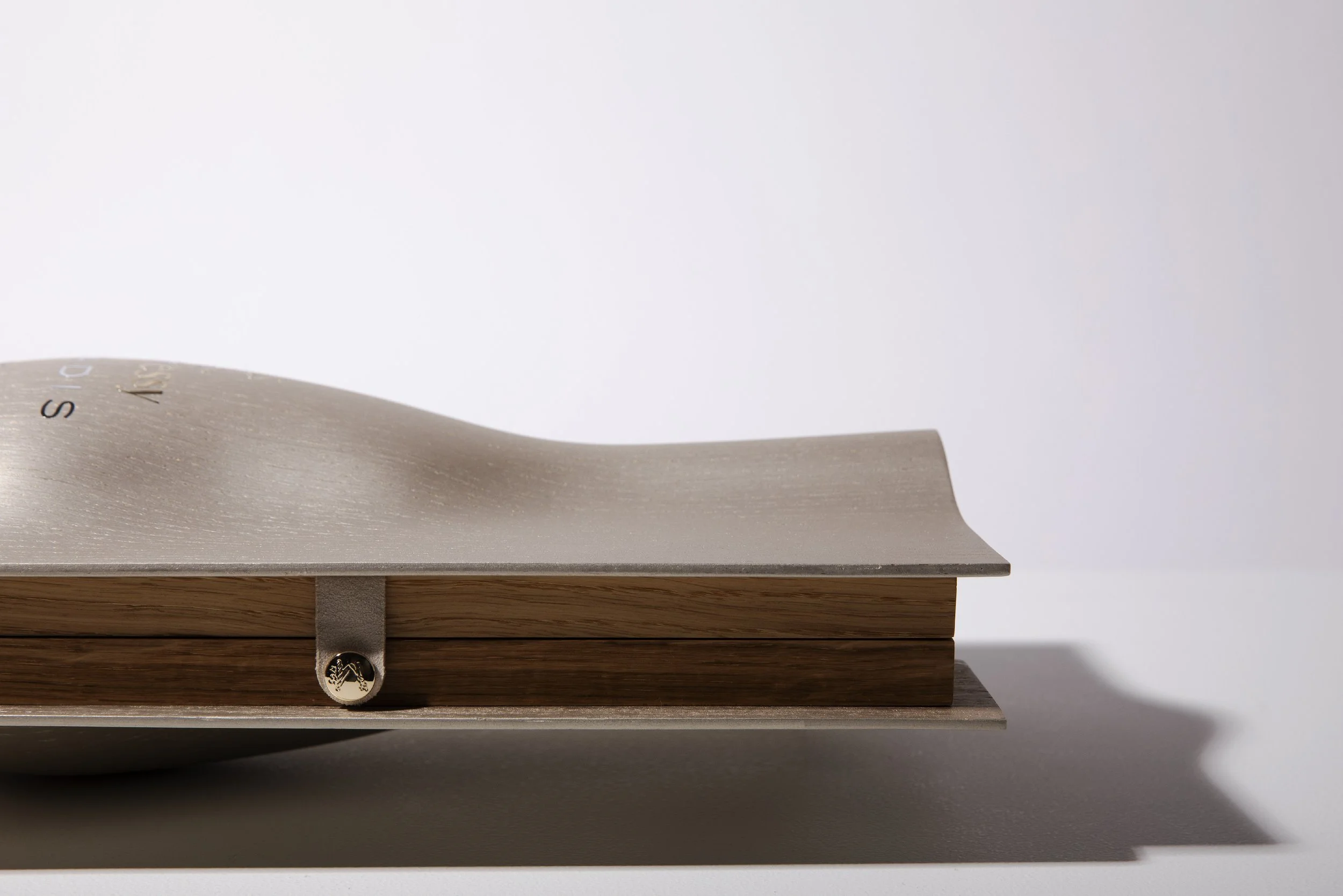 Close-up of a sleek metallic and wooden mechanical watch with minimalistic design