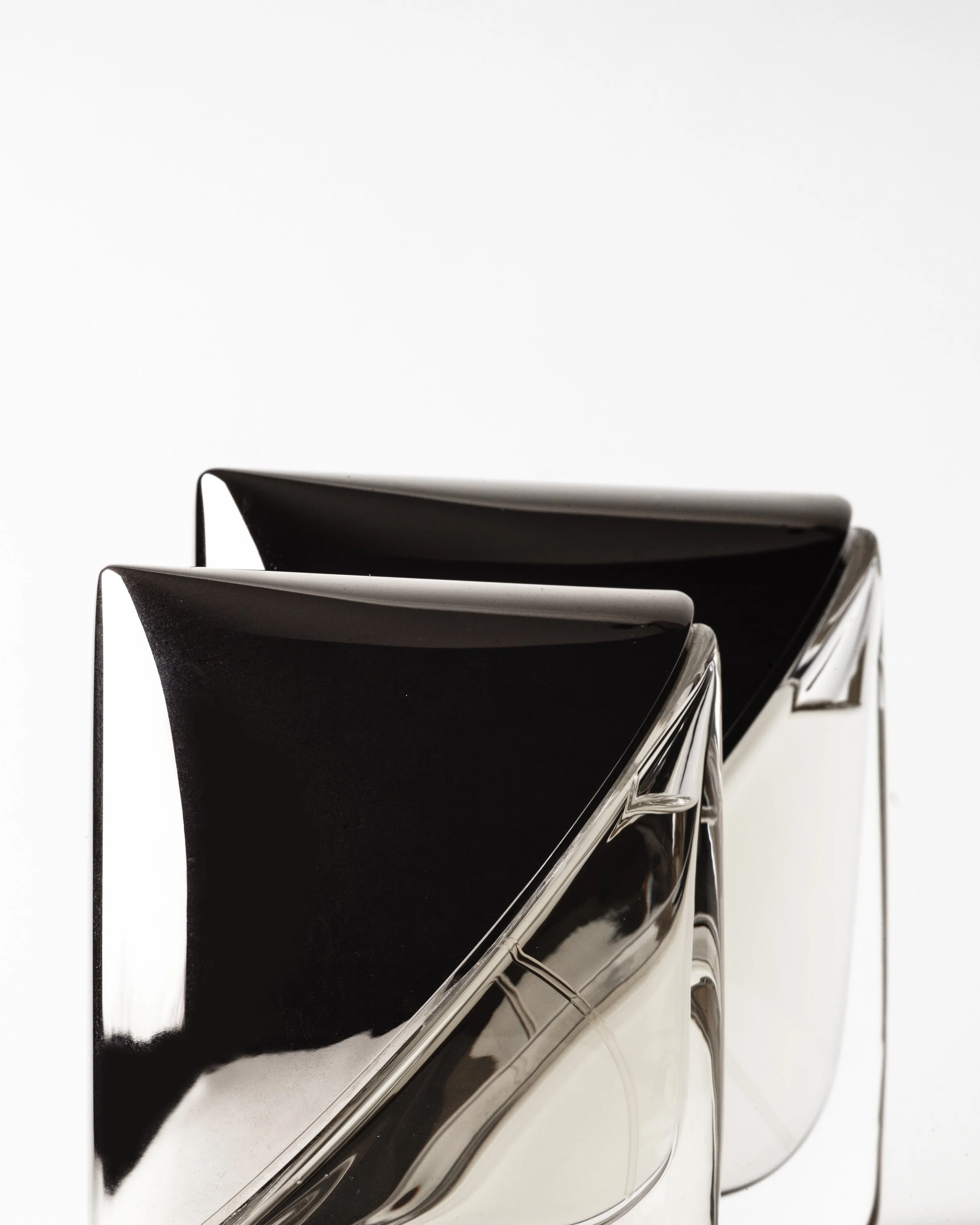 Two modern, black and silver chairs with curved backs and metal legs against a plain white background.