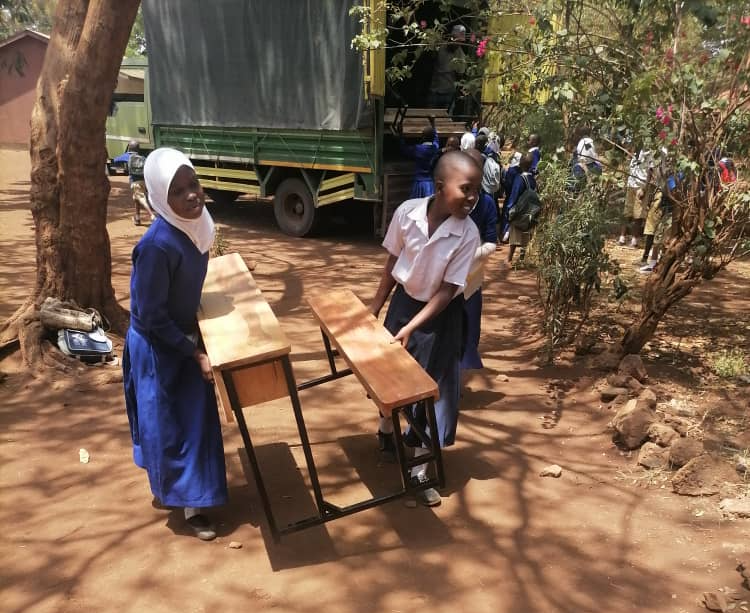  Students bringing the new benches into the classroom. 