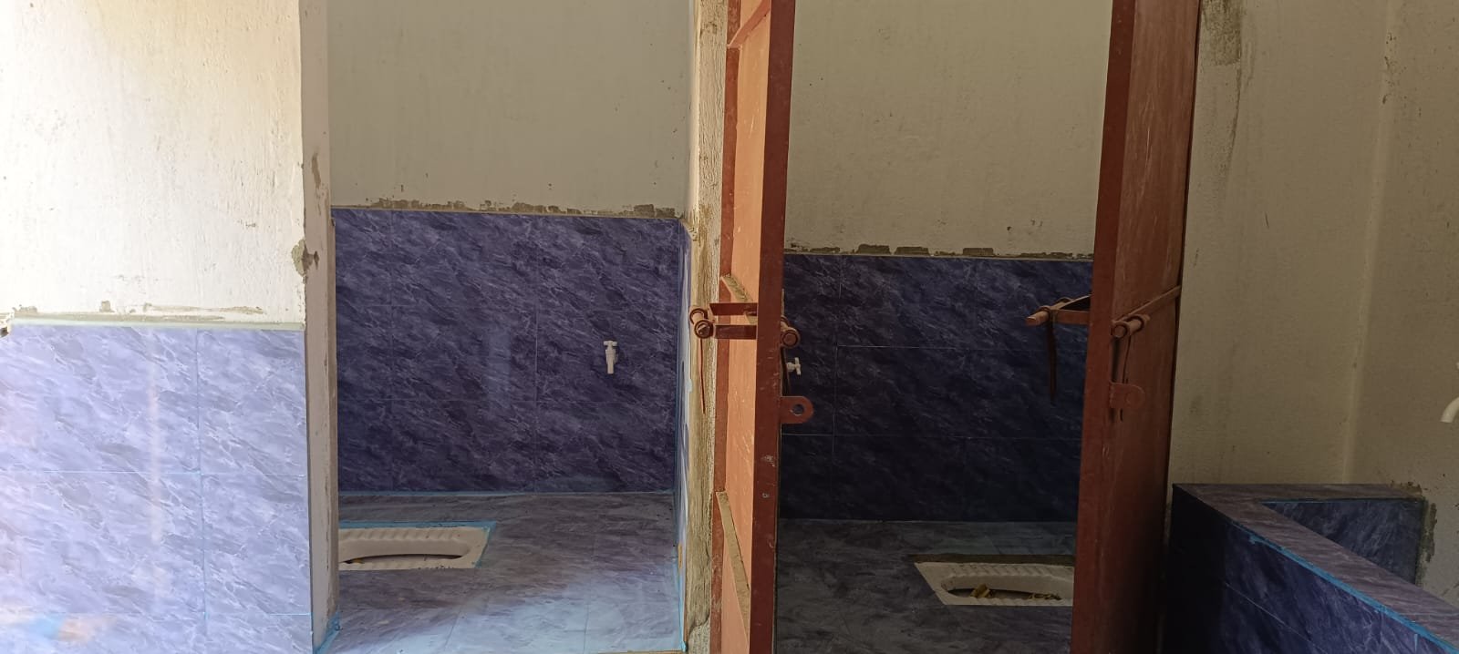  The interior of the building with two squat style toilets. 