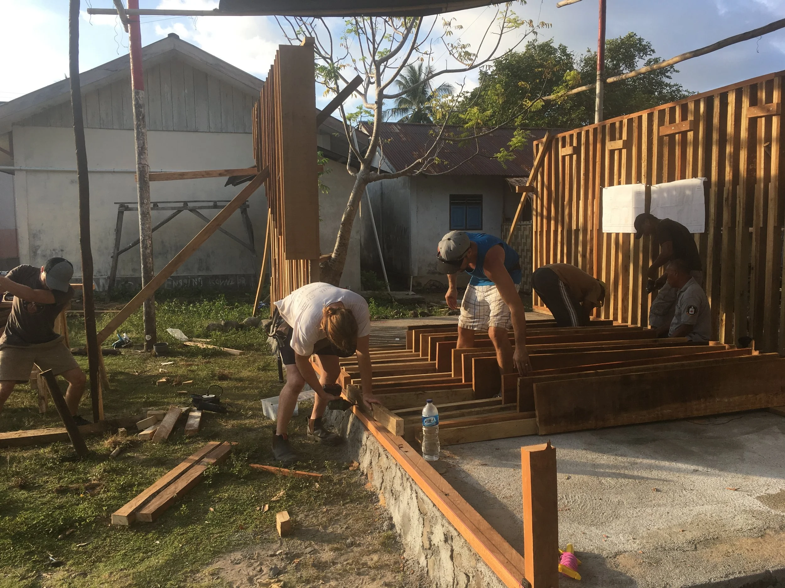  The local volunteers working with Learn to Live work at building out the structure that will house the water tanks. 