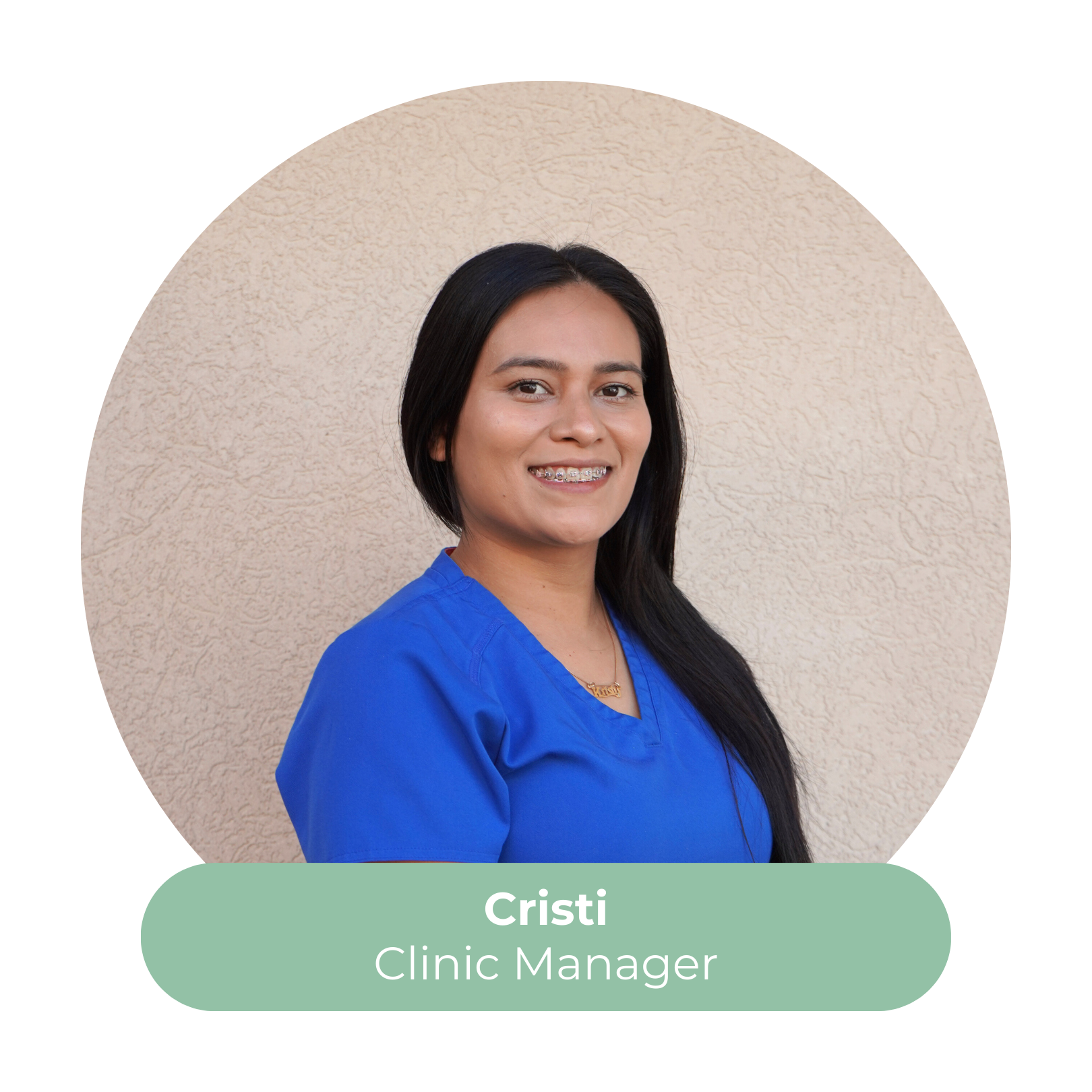 A woman with long dark hair and braces, wearing blue scrubs, smiling, standing against a beige textured wall. Text overlay reads 'Cristi, Clinic Manager'.