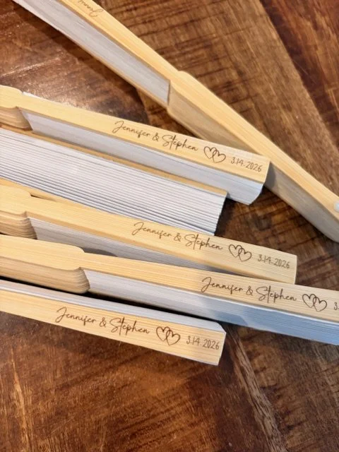wooden fans engraved with the bride and groom's name and date