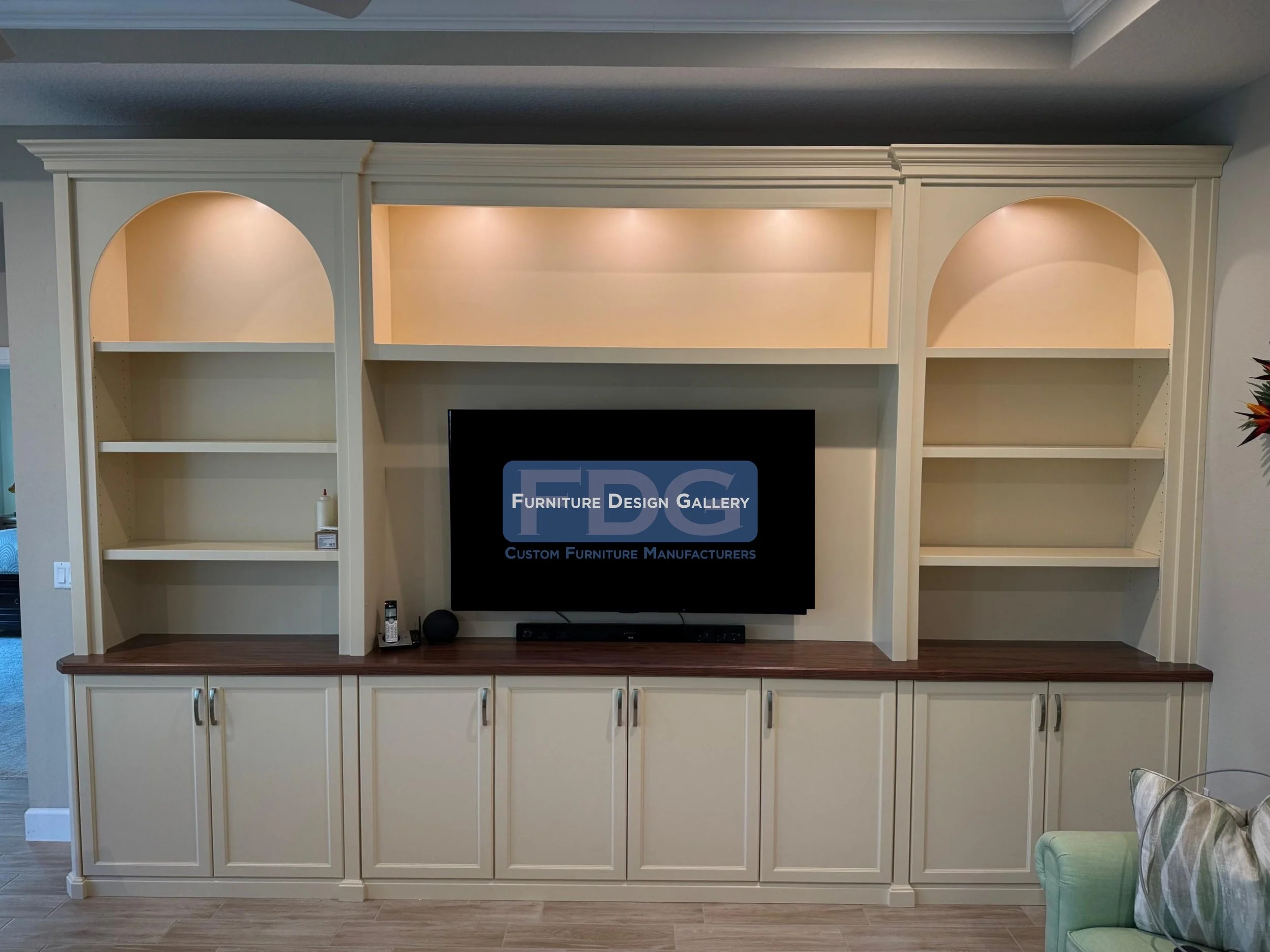 37. Sophisticated and seamless. This custom cream wall unit features elegant arched shelving, integrated lighting, and a rich wood-tone countertop for a perfect blend of storage and style.