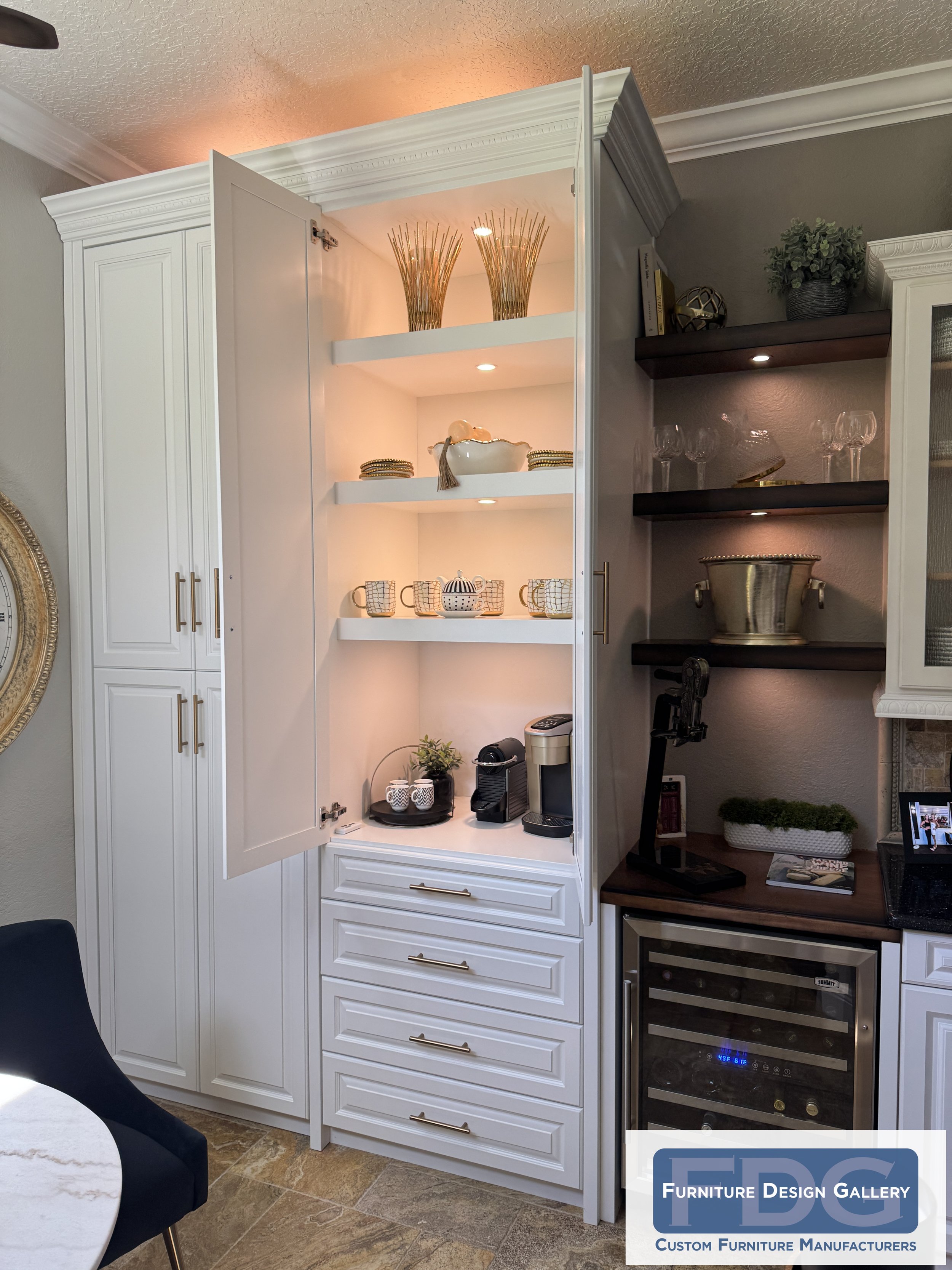 1. Elevate your morning routine. This custom coffee station features stow-away doors, warm puck lighting, and gold-accented hardware, perfectly paired with a built-in wine cooler for seamless day-to-night entertaining.