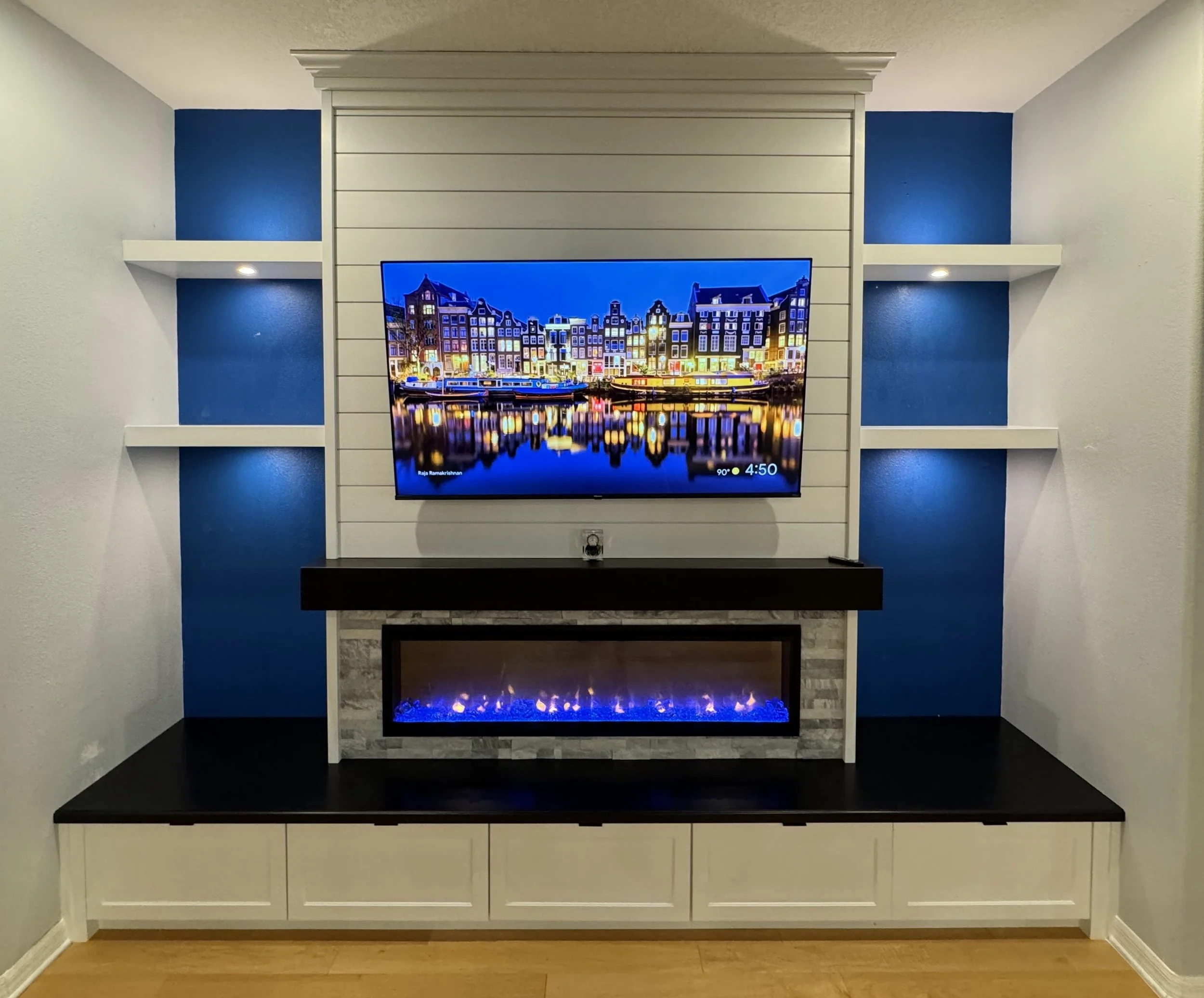 17. Bold and coastal-inspired. This custom unit makes a statement with a white shiplap focal point, vibrant blue accents, and integrated lighting that perfectly frames the sleek fireplace and media center.