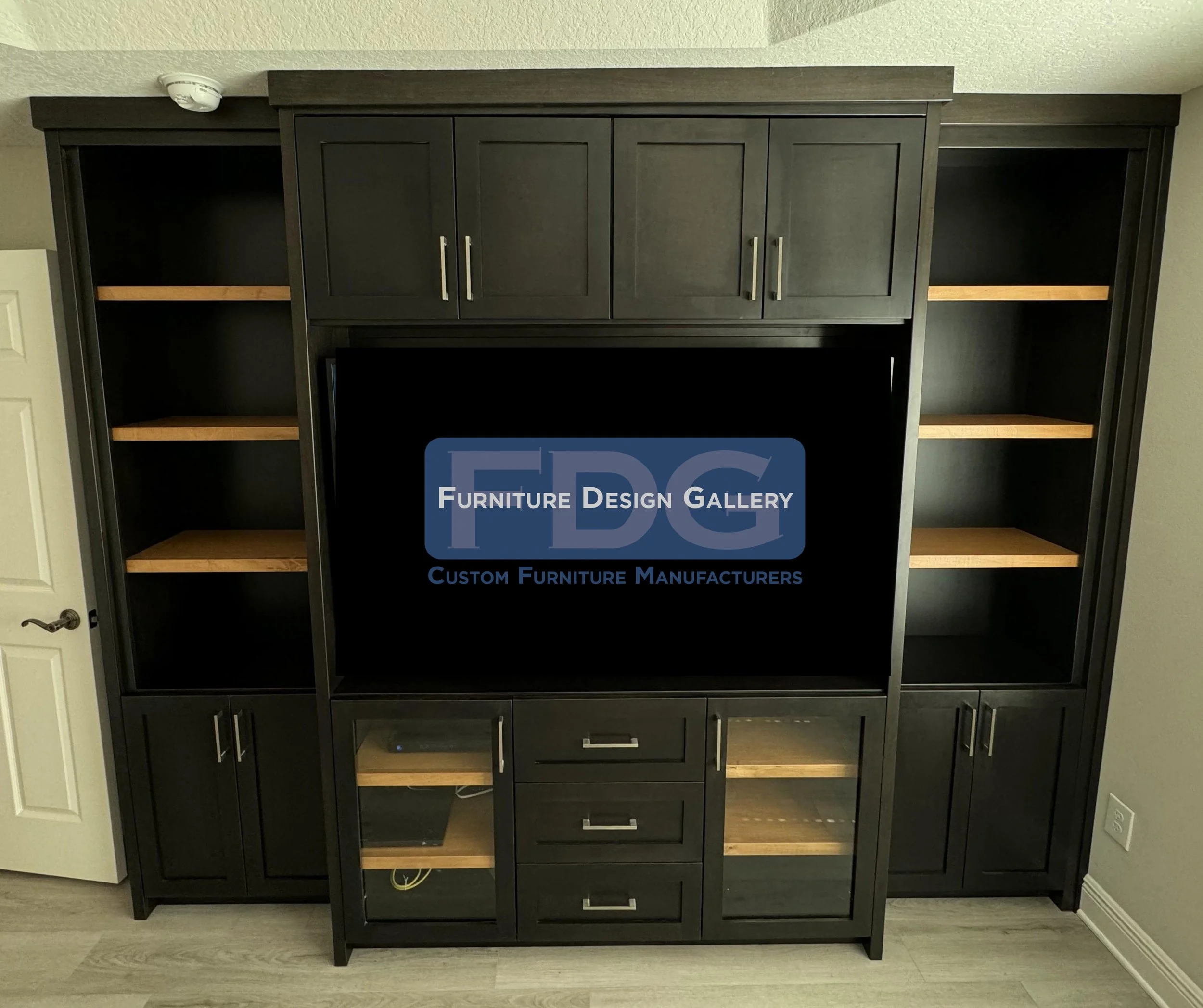 41. Bold, dark, and sophisticated. This custom espresso wall unit makes a statement with its tiered design, glass-front cabinetry, and warm wood shelving that provides a striking contrast.