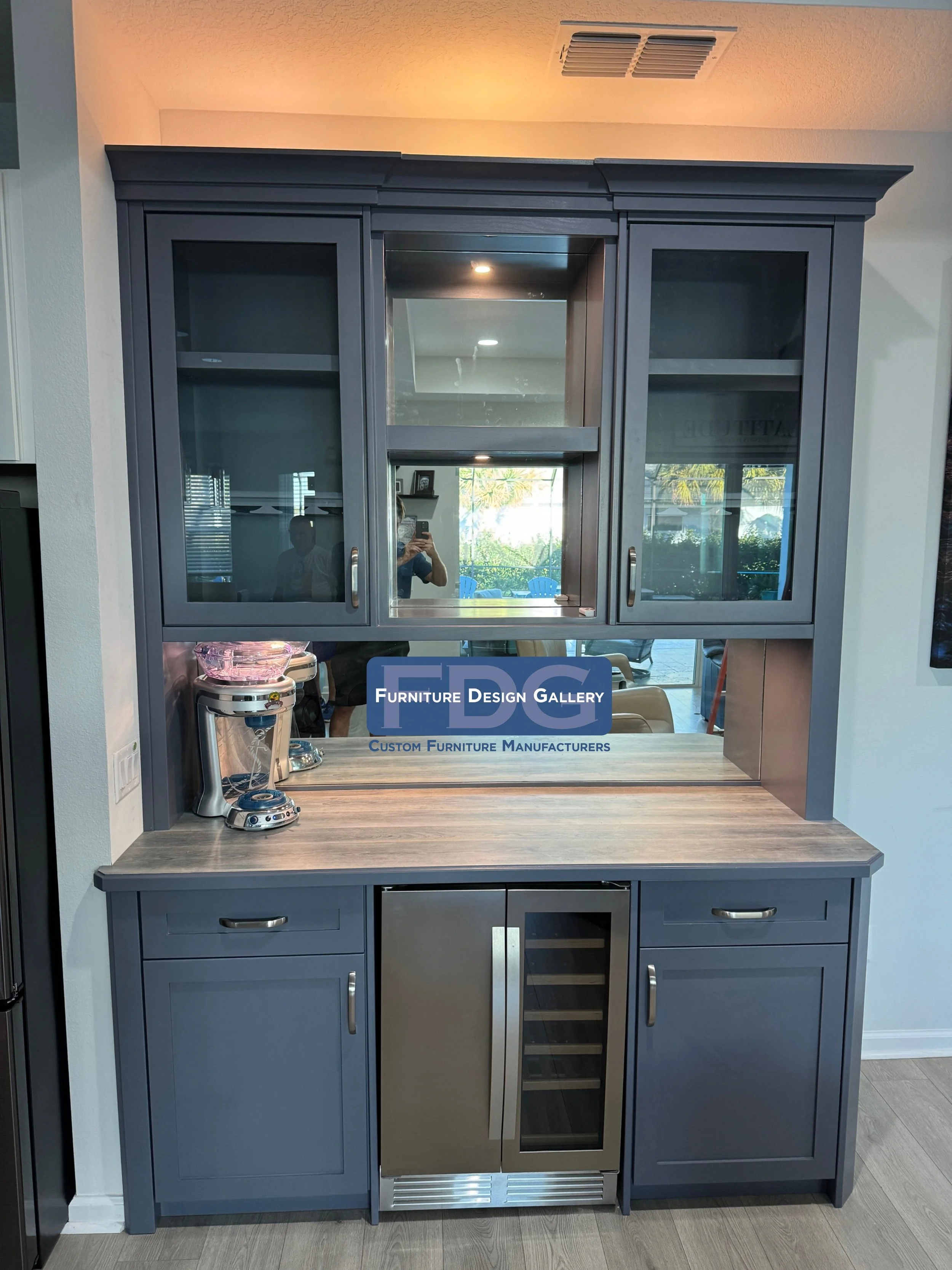 4.  Custom Home Bar Unit | Slate blue cabinetry featuring integrated wine cooling, mirrored backsplash, and glass-front display uppers with accent lighting.